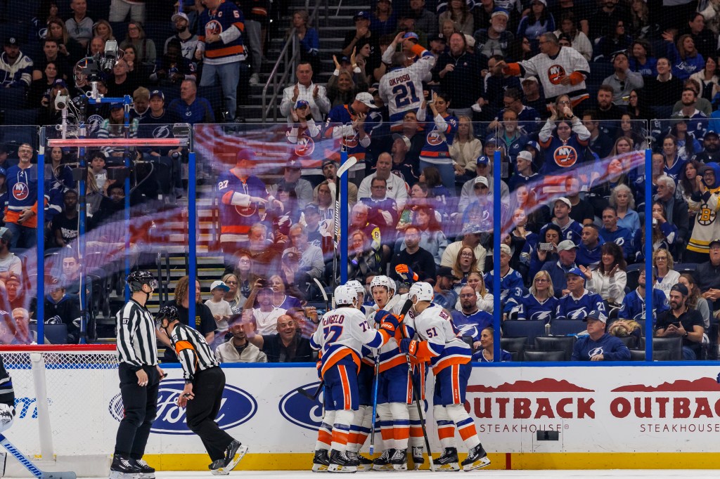 New York Islanders players celebrate a goal on the ice.