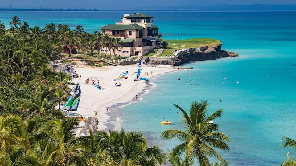 mansion at coastal city with tropical trees and beach