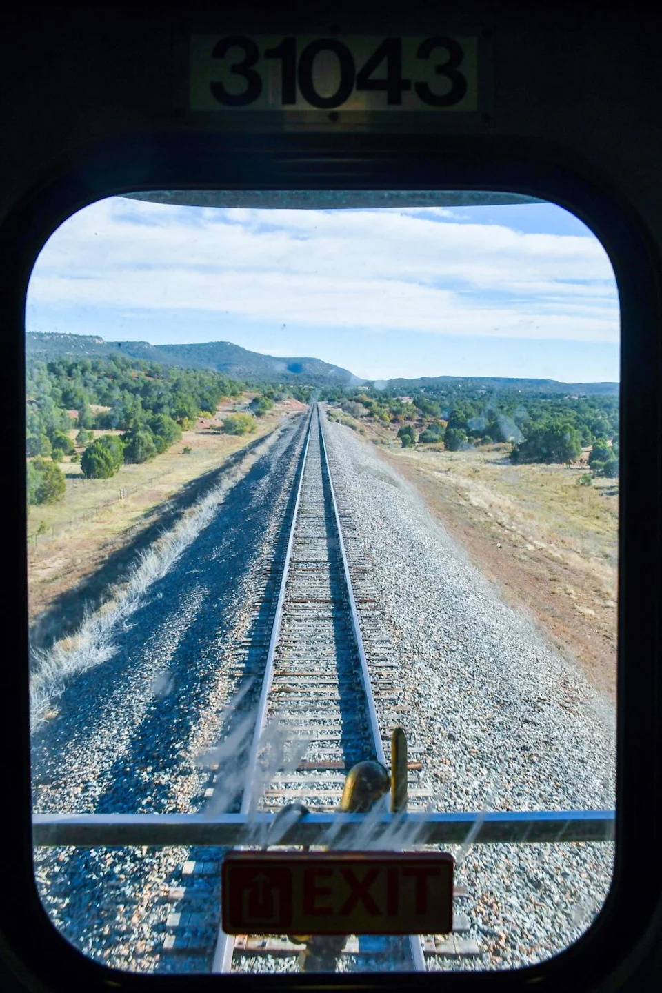 Tracks dominate the view from the last car on the train.