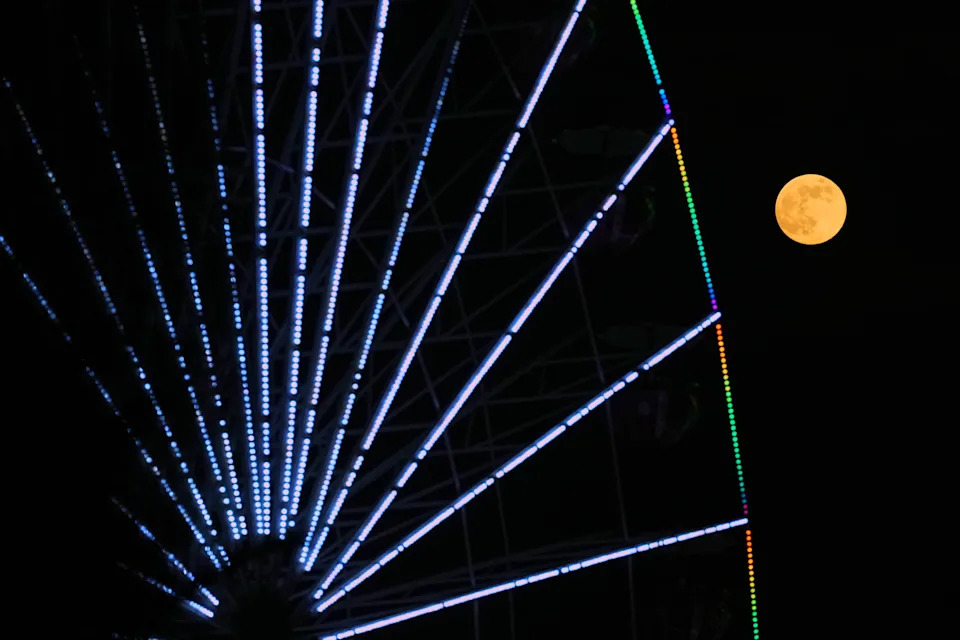 The last full moon of the year rises in the sky behind a Christmas celebrations wheel in Nicosia, Cyprus.