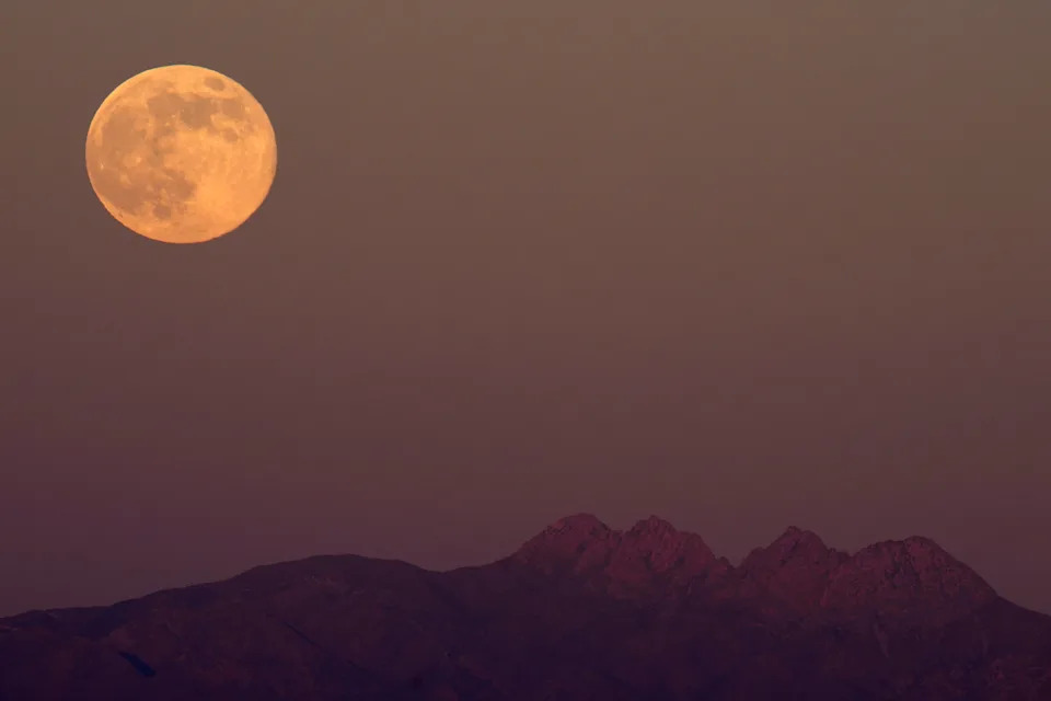 The cold moon rises over the Superstition Mountains in Phoenix.