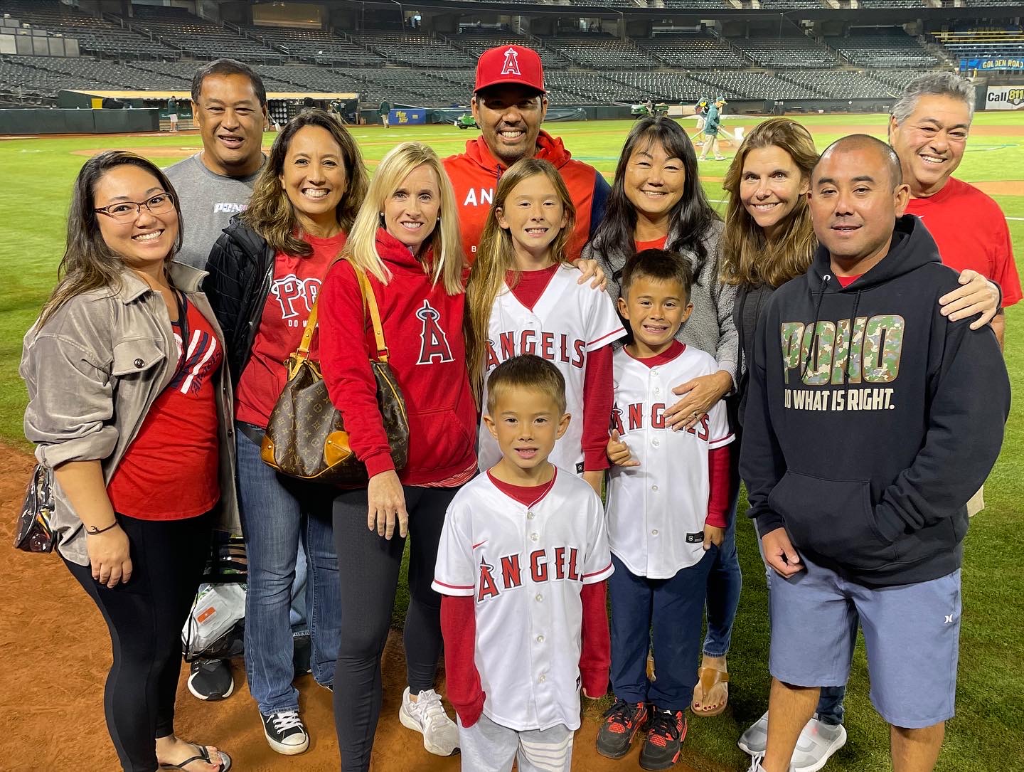 At Kurt Suzuki's final game of his 16-year Major League Baseball career on Oct. 4, 2022 — his 39th birthday — friends and family posed for this photo. Kurt Suzuki is in the back center wearing his Los Angeles Angels hats. From left, Keisha Shishiido, Jon Viela, Maile Viela, Renee Suzuki, Eli Suzuki (front), Malia Suzuki, Kai Suzuki, Wendy Shishido, Brianna Wainecki, Kimo Higa and Kahai Shishido. Photo courtesy of Kimo Higa