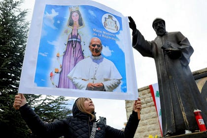 A woman holds up a placard with the images of Pope Leo XIV and "Mary, Madonna of Reparation" next to a statue of St Charbel on the day Pope Leo XIV visits the Monastery of Saint Maroun, in Annaya, Lebanon on Monday. Credit: Mohamed Azakir/REUTERS A woman holds up a placard with the images of Pope Leo XIV and "Mary, Madonna of Reparation" next to a statue of St Charbel on the day Pope Leo XIV visits the Monastery of Saint Maroun, in Annaya, Lebanon on Monday.