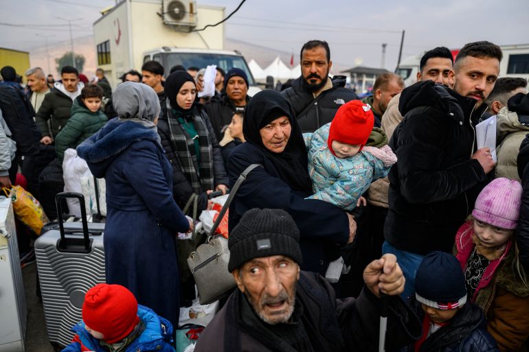 Syrian refugees living in Turkey wait in a queue to enter Syria