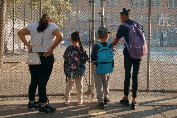 A 5-year-old migrant child from Eduador, center right, arrives to school in New York in September 2023.