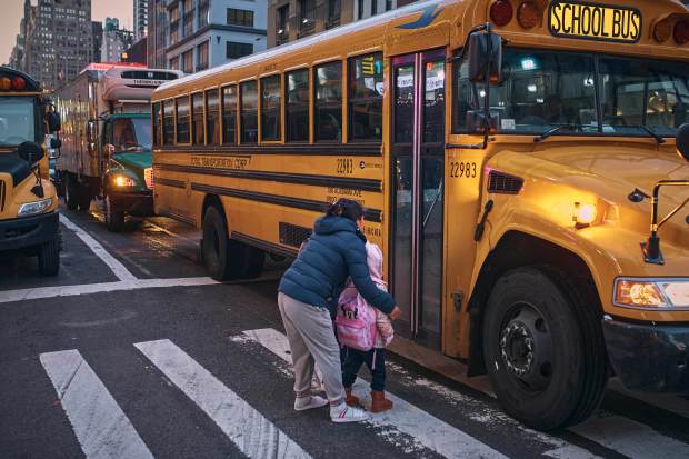 Children take a school bus in front of a migrant shelter in Manhattan in December 2023.