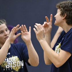 Gallaudet's women's volleyball player Ashlene Etkie, left, communicates with teammate Cassidy Perry using American Sign Language as their team prepares for the upcoming Division III NCAA Tournament, during a practice Monday, Nov. 18, 2024, in Washington. (AP Photo/John McDonnell)