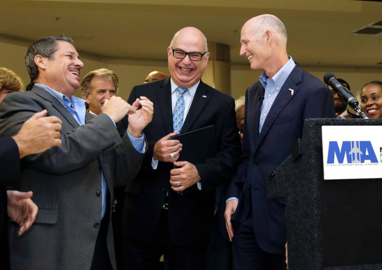 Florida Gov. Rick Scott, right, laughs with Emilio Gonzalez, director and chief executive officer of the Miami-Dade Aviation Departmen