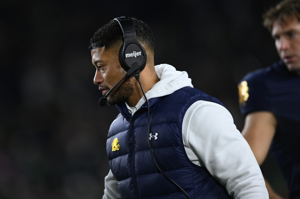 Notre Dame head coach Marcus Freeman, left, looks on during the fourth quarter of an NCAA football game against Syracuse, Saturday, Nov. 22, 2025, in South Bend, Ind.