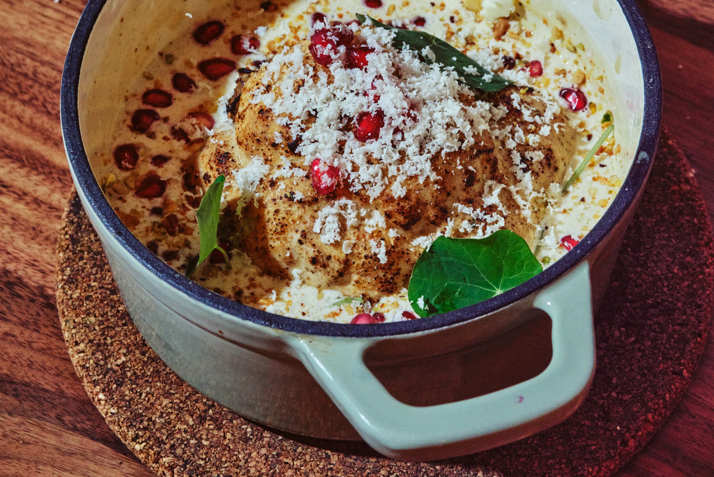 A roasted cauliflower dish in a blue baking dish.