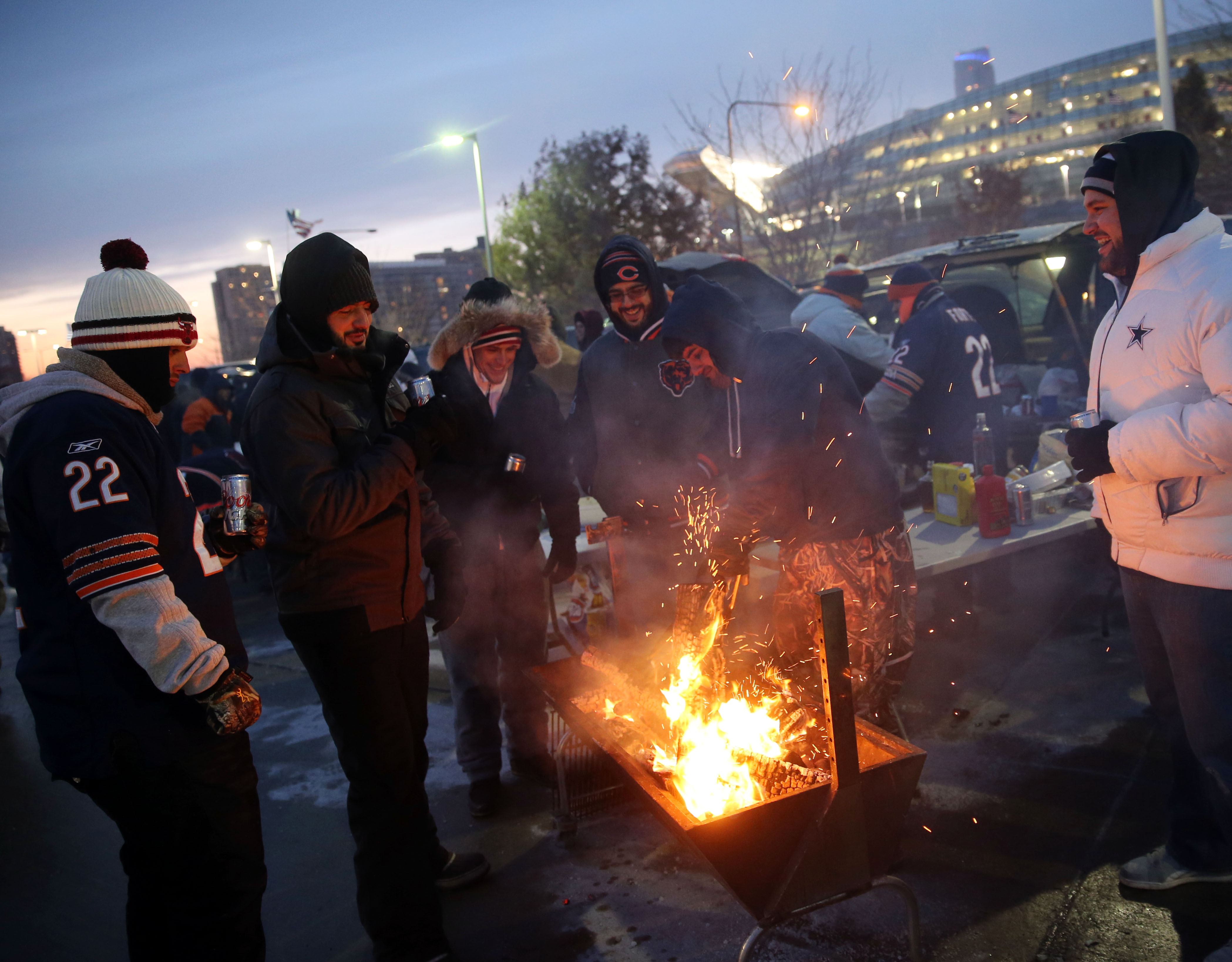 Fans build a fire while tailgating before the game between...