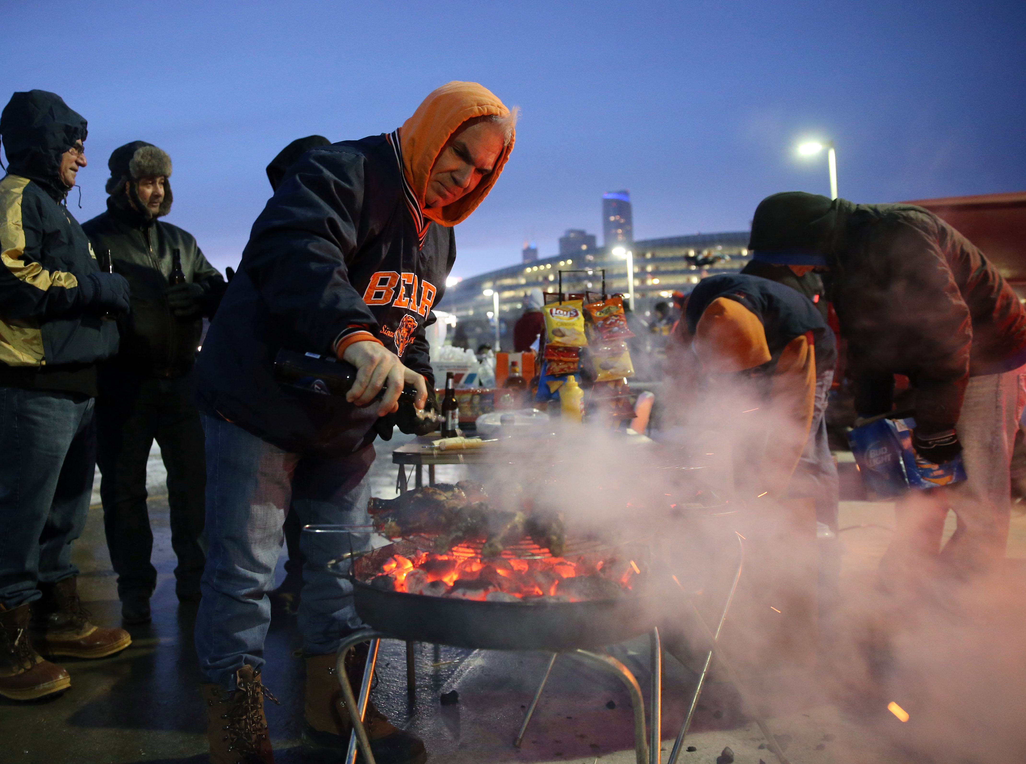 Lou Gikas of Munster, Ind., mans the grill while tailgating...