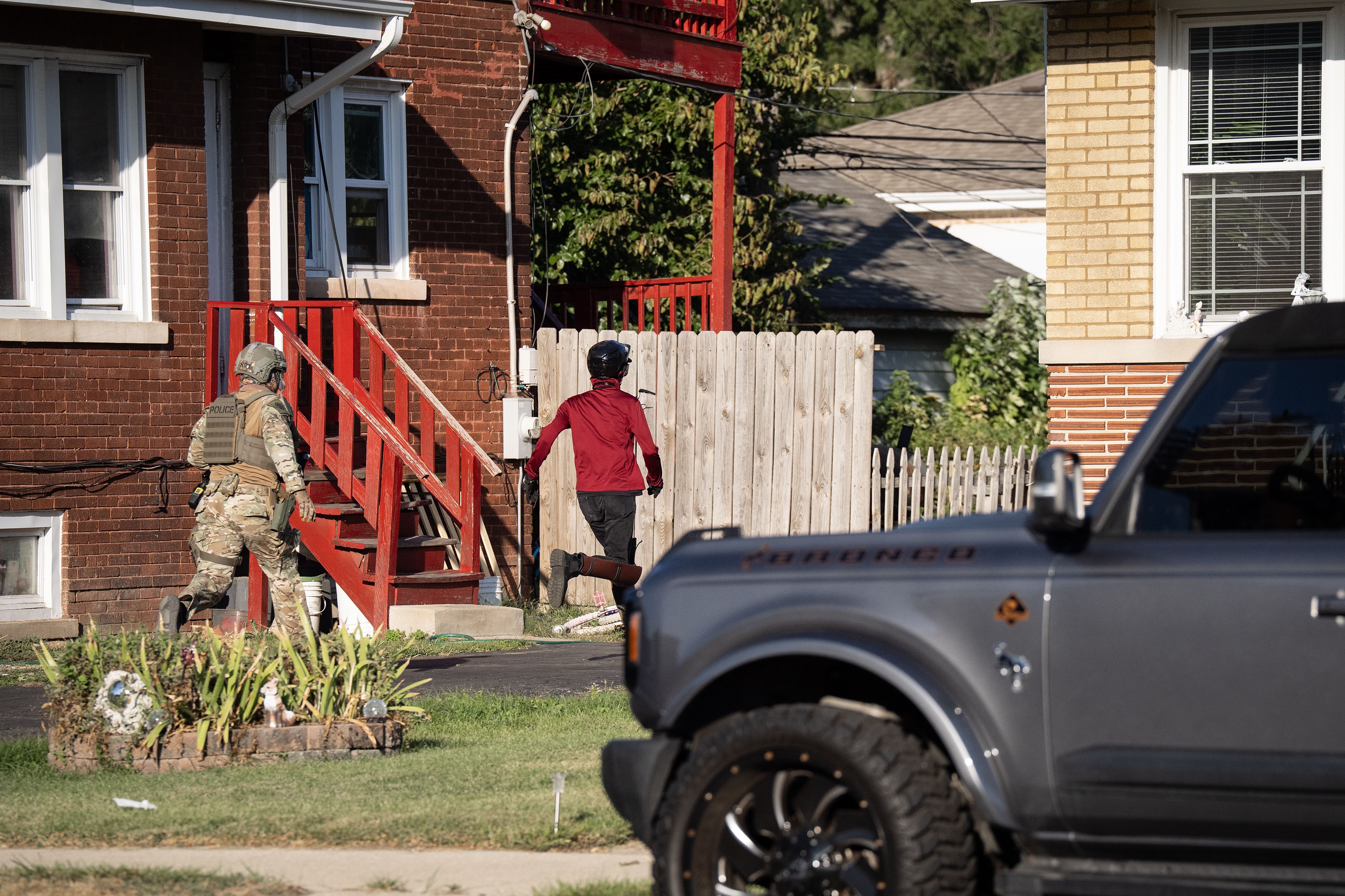 An ICE agent chases a protester into residential yard near...