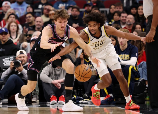 Bulls forward Matas Buzelis, left, and Pacers guard Ethan Thompson reach for a loose ball in the second quarter at the United Center on Dec. 5, 2025, in Chicago. (John J. Kim/Chicago Tribune)