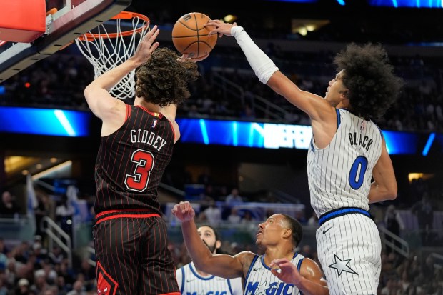 Magic guard Anthony Black blocks a shot by Bulls guard Josh Giddey during the second half Monday, Dec. 1, 2025, in Orlando, Fla. (AP Photo/John Raoux)