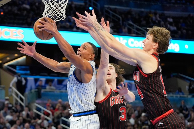 Magic guard Desmond Bane grabs an offensive rebound away from Bulls guard Josh Giddey (3) and forward Matas Buzelis during the first half Monday, Dec. 1, 2025, in Orlando, Fla. (AP Photo/John Raoux)