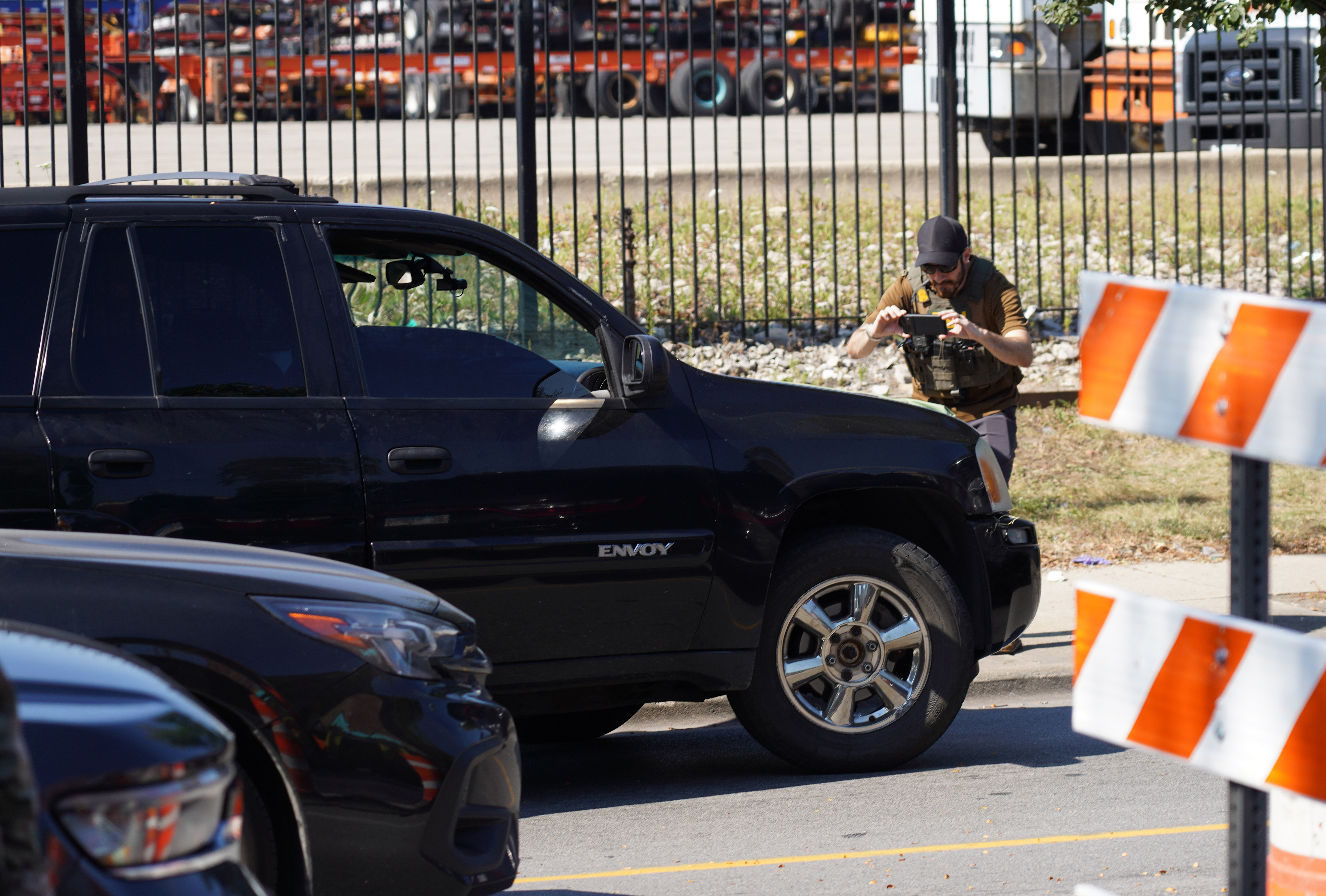Federal immigration agents conduct an investigation with a vehicle in...