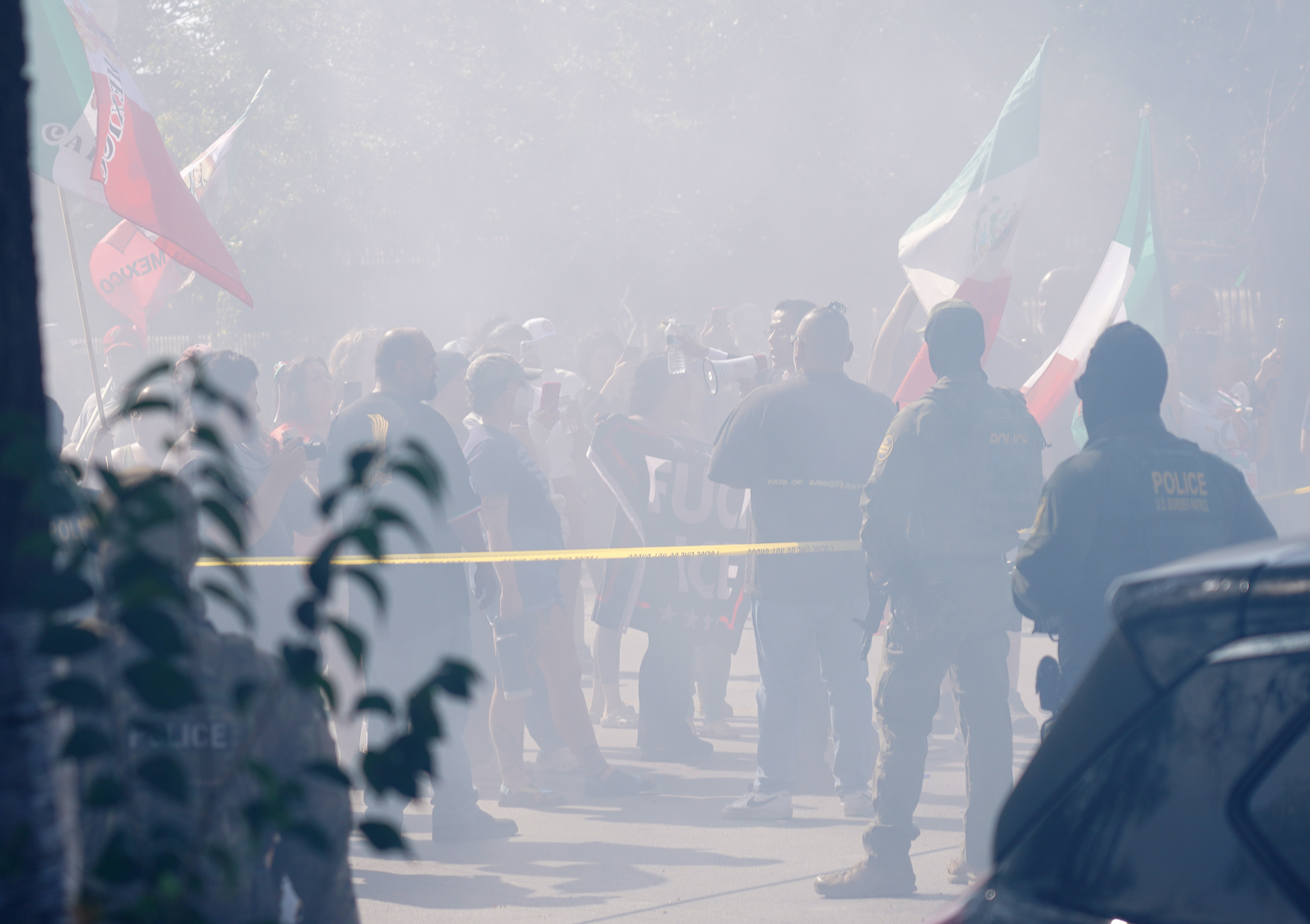 Tire smoke from a squealing car fills the air as...