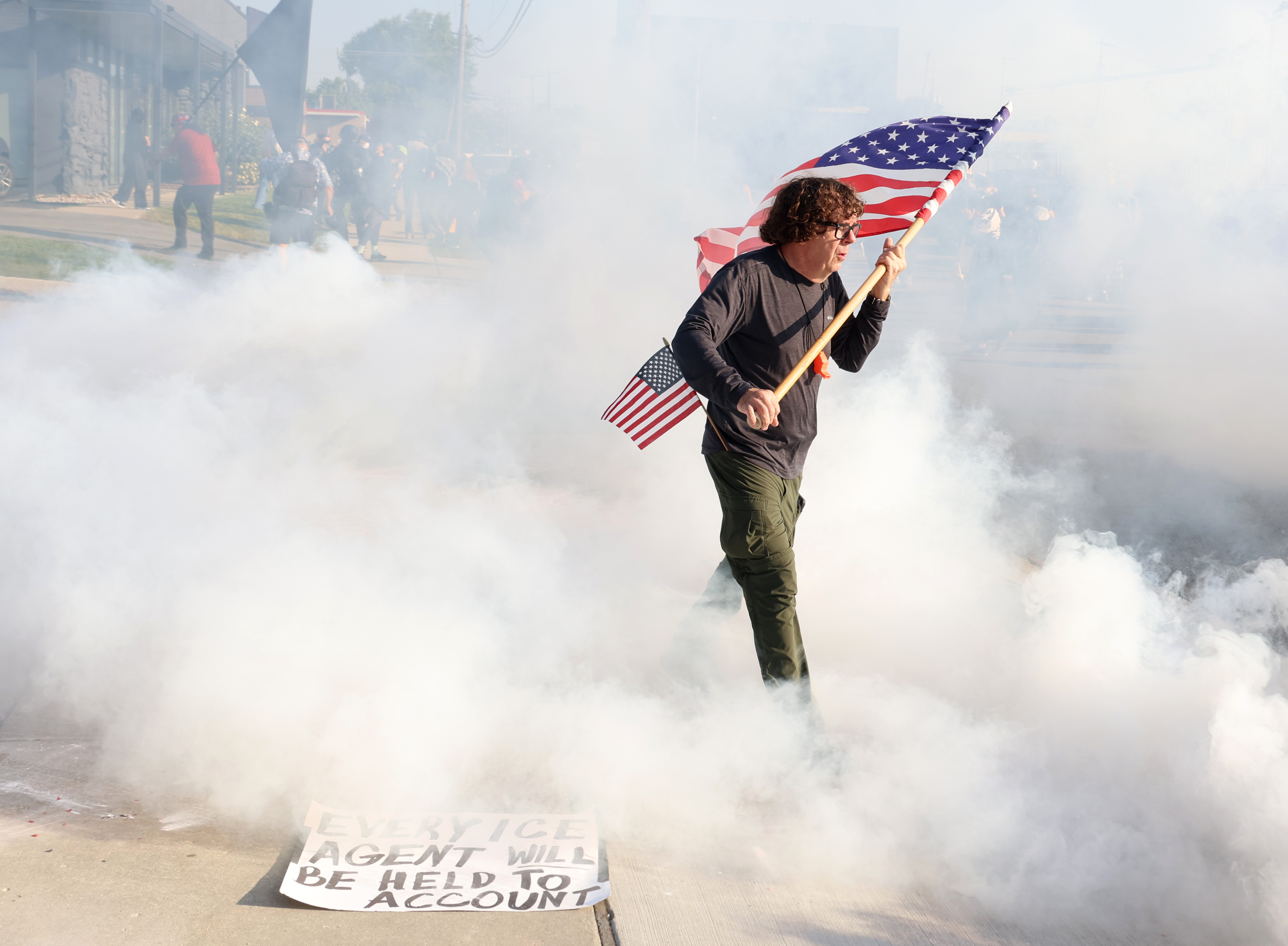 Curtis Evans, of Evanston, carries a U.S. flag through gas...