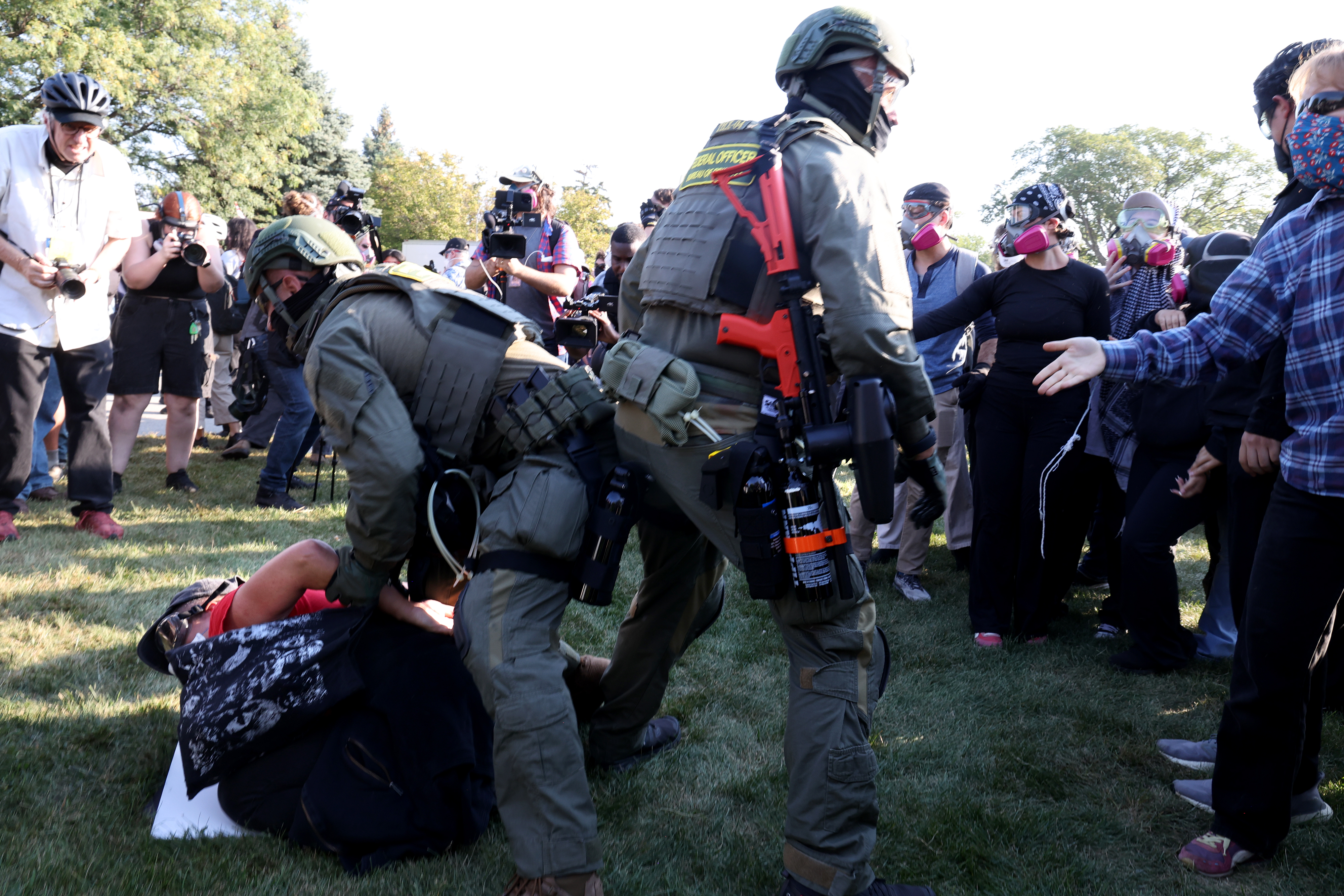 A protester is detained near the U.S. Immigration and Customs...