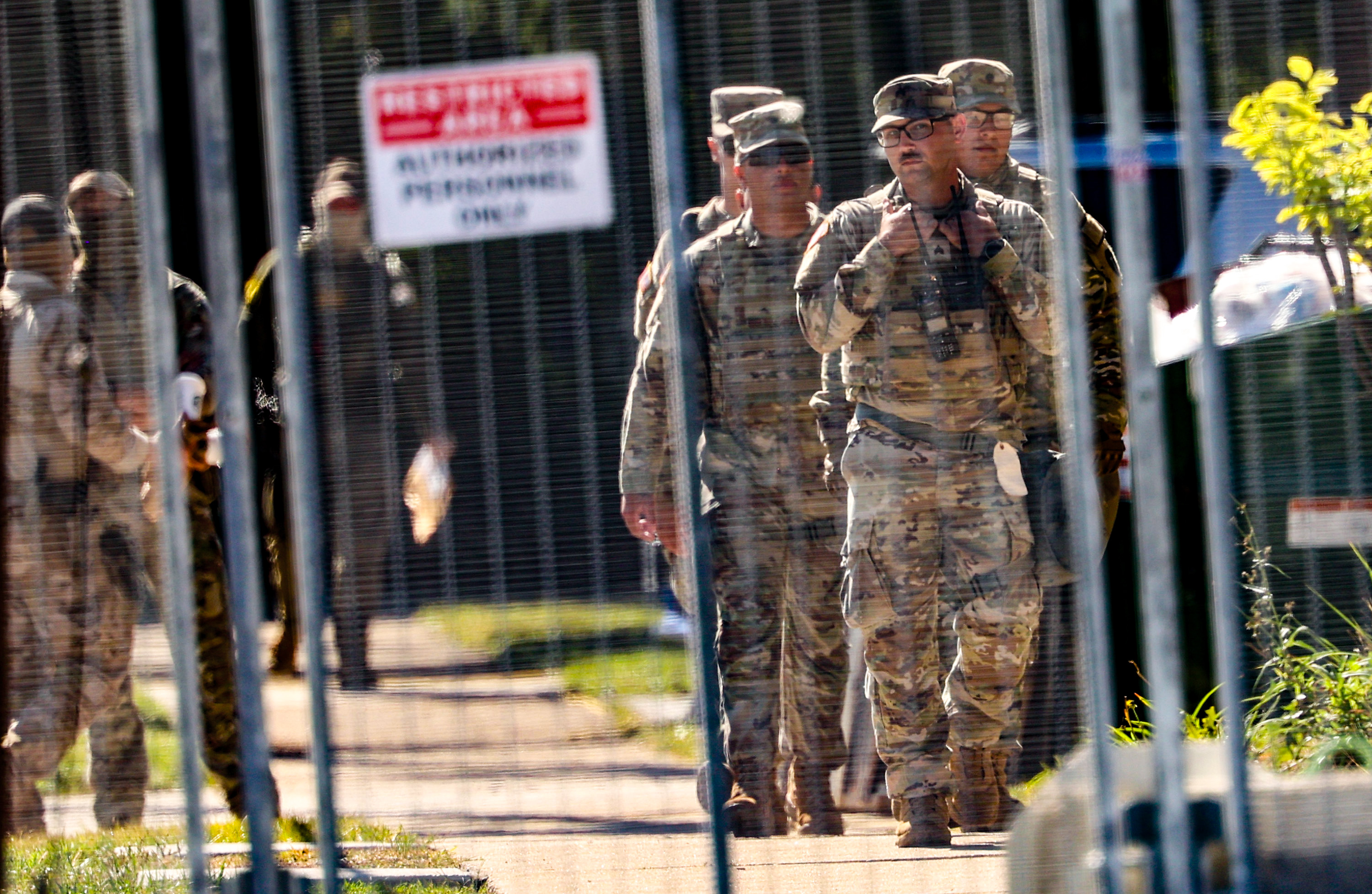 Texas National Guard members walk outside of the U.S. Immigration...