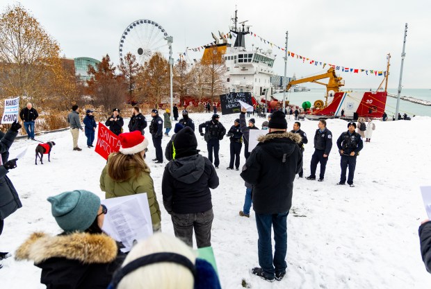 Protesters sing parody Christmas carols about U.S. Secretary of Homeland Security Kristi Noem's appearance at the 25th Anniversary Voyage of Chicago's Christmas Ship, USCGC Mackinaw, Saturday, Dec. 6, 2025, at Polk Brothers Park next to Chicago's Lake Michigan. (Dominic Di Palermo/Chicago Tribune)