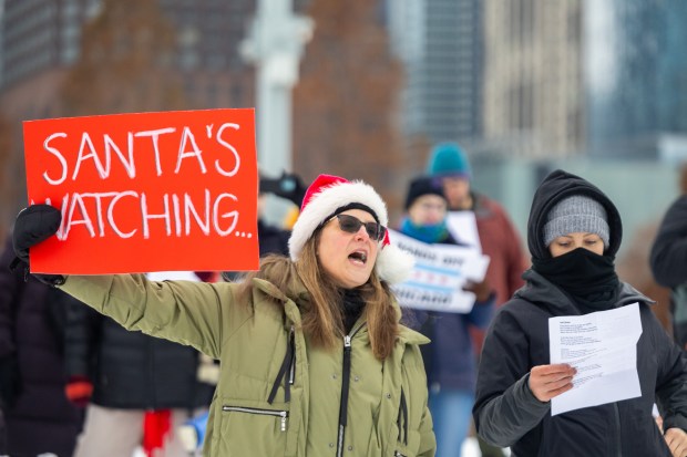Protesters sing parody Christmas carols about U.S. Secretary of Homeland Security Kristi Noem's appearance at the 25th Anniversary Voyage of Chicago's Christmas Ship, USCGC Mackinaw, Saturday, Dec. 6, 2025, at Polk Brothers Park next to Chicago's Lake Michigan. (Dominic Di Palermo/Chicago Tribune)