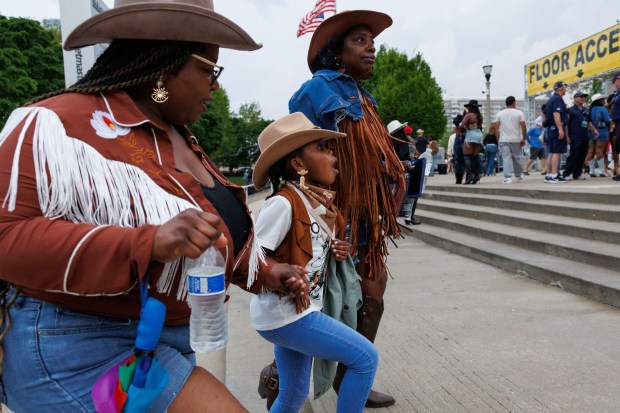 Sakara Heade, from left, her daughter Micah Heade, and Adelia White, all from Detroit, walk toward Soldier Field before the first Chicago night of Beyoncé's Cowboy Carter performance, May 15, 2025. (Armando L. Sanchez/Chicago Tribune)