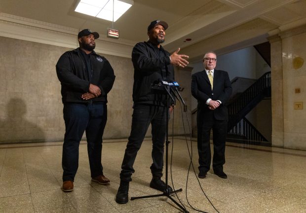 Illinois Black Hemp Association co-founder Tyrone Muhammad speaks while co-founder Samuel Wilson, left, and Craig Katz, president of board of Illinois Healthy Alternatives Association, look on during a press conference discussing a proposed hemp product sales ban by the City Council on Dec. 3, 2025. (Dominic Di Palermo/Chicago Tribune)