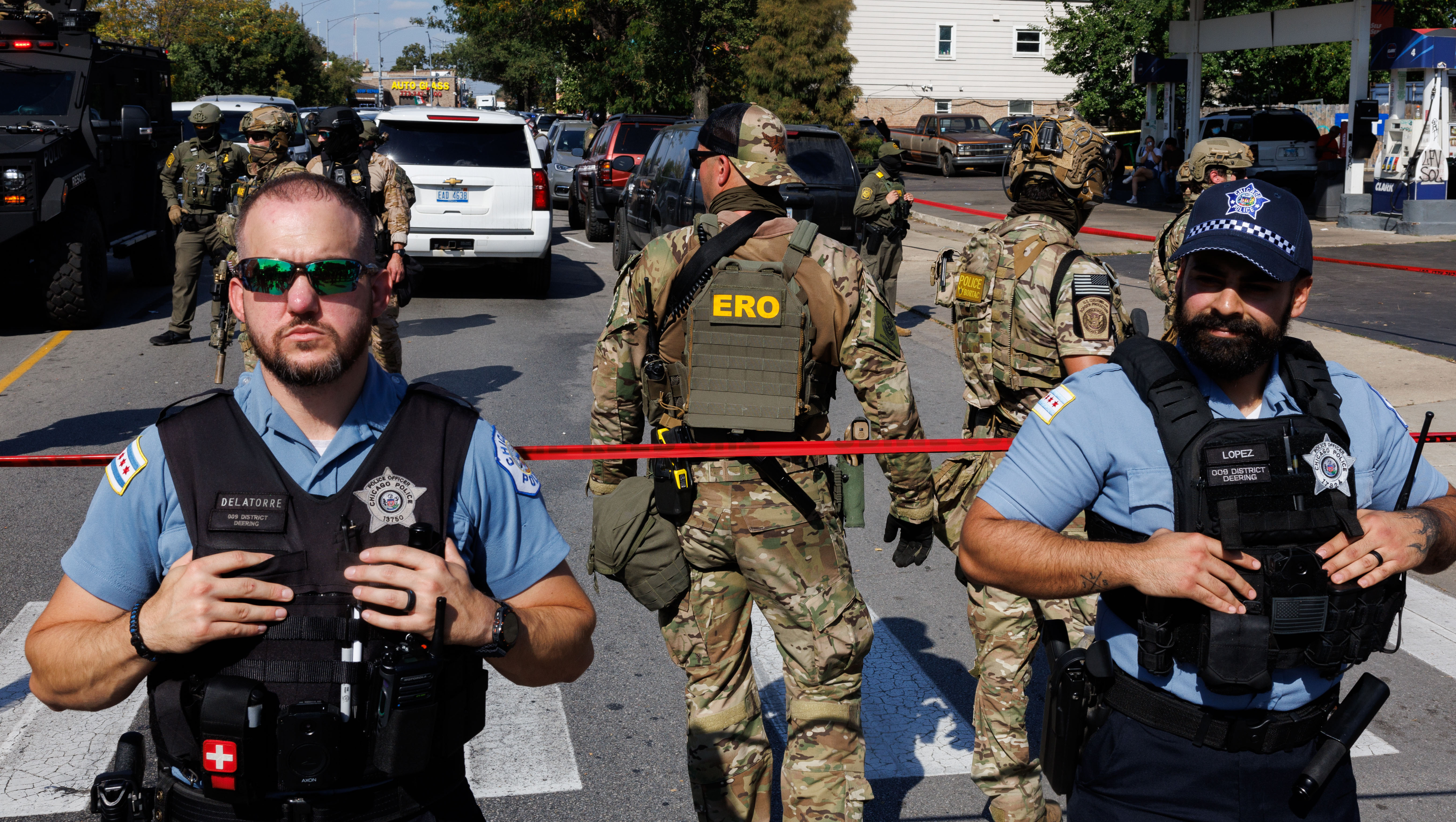 Chicago police are posted near federal agents as community members...
