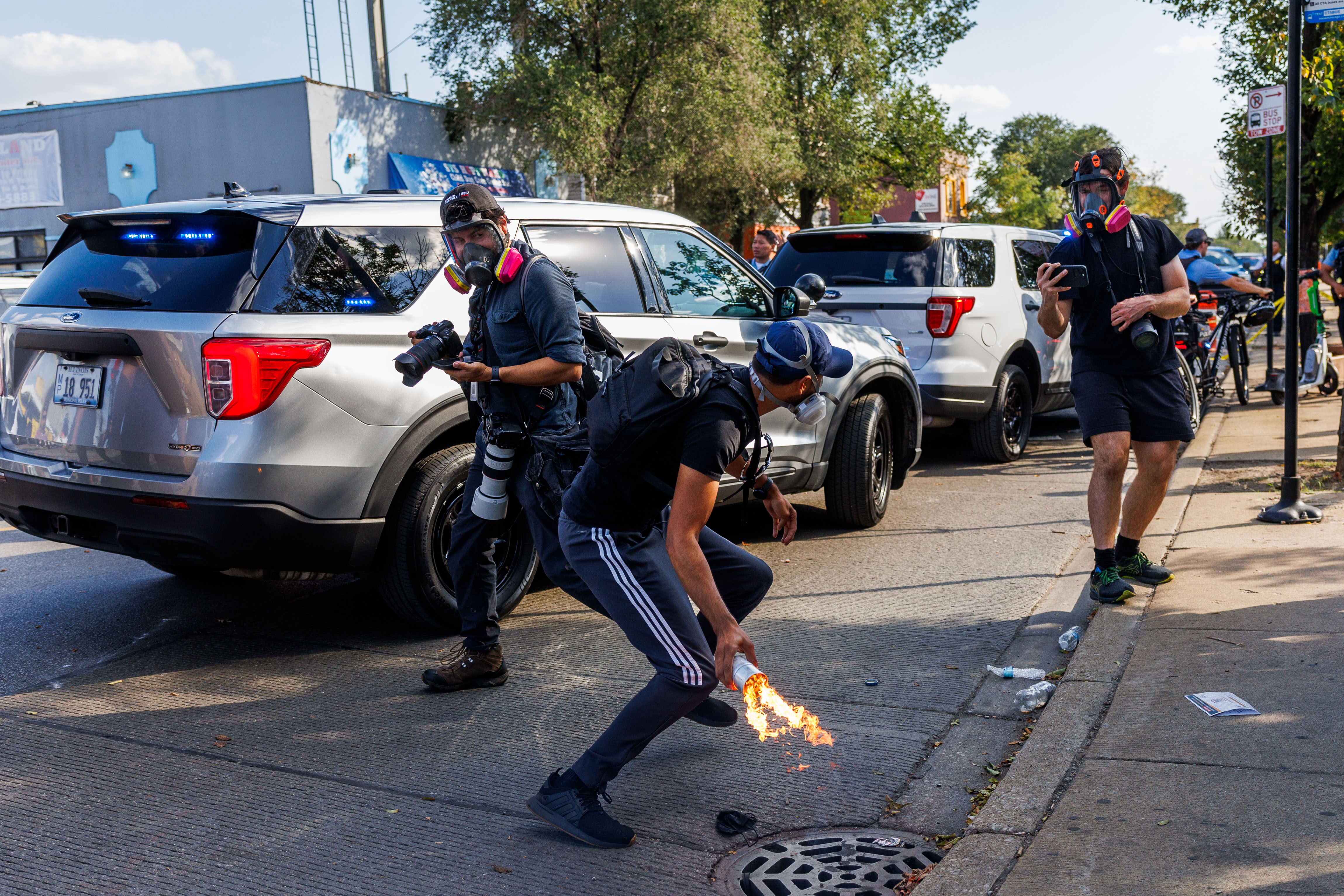 A protester throws a chemical agent canister back toward Chicago...
