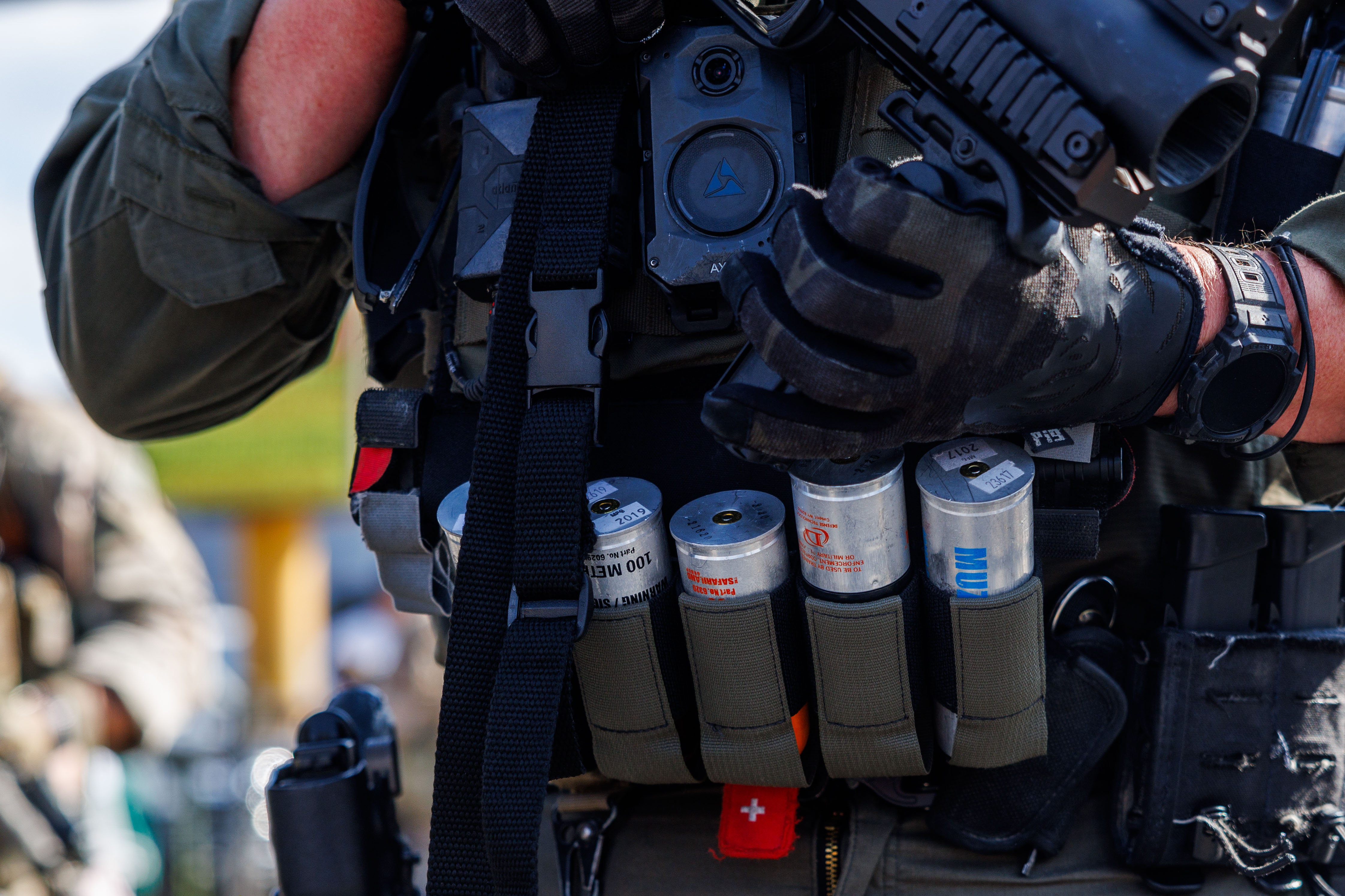 A federal agent holds a launcher that fires gas canisters...