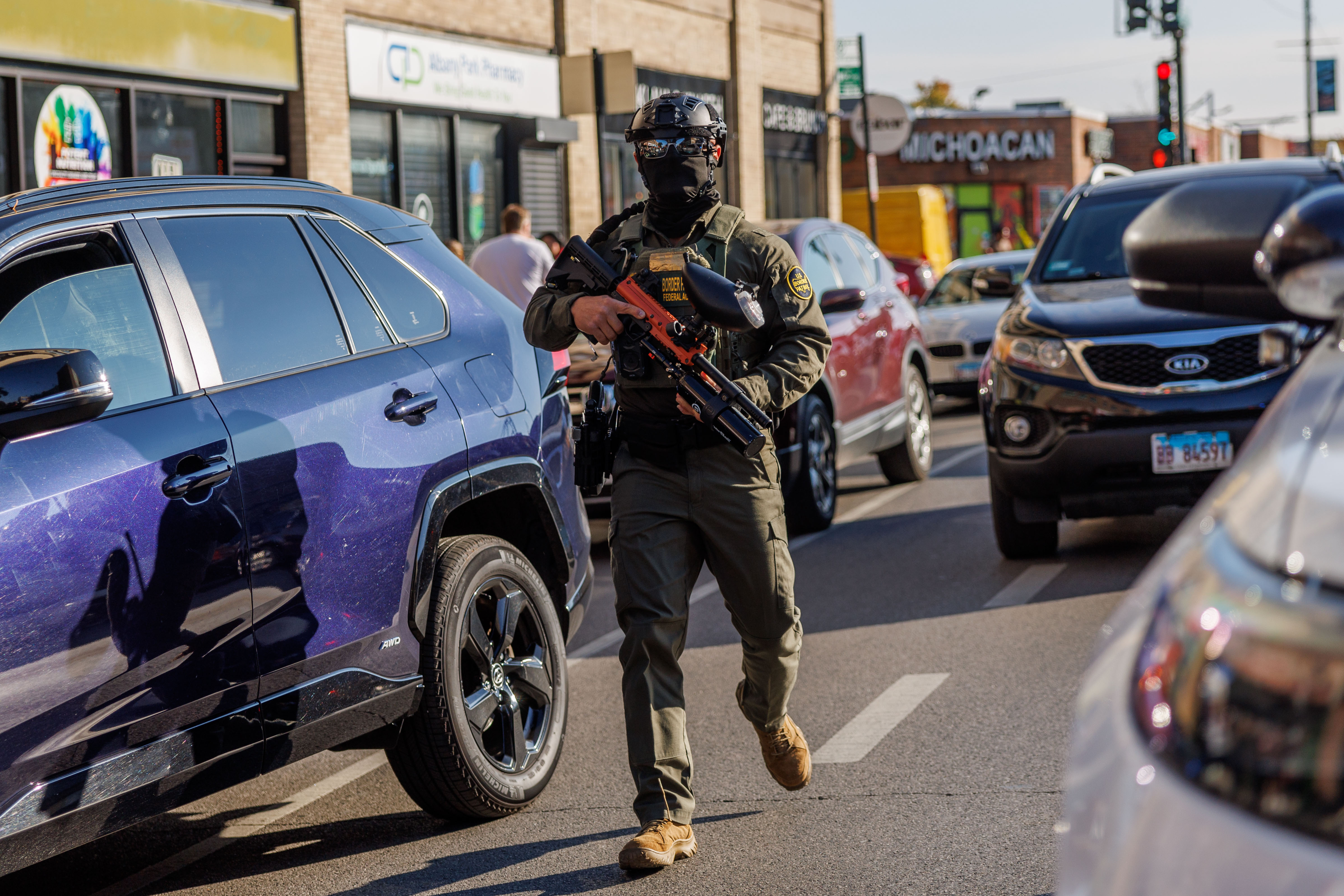 Border Patrol officers stand in the street while detaining a...