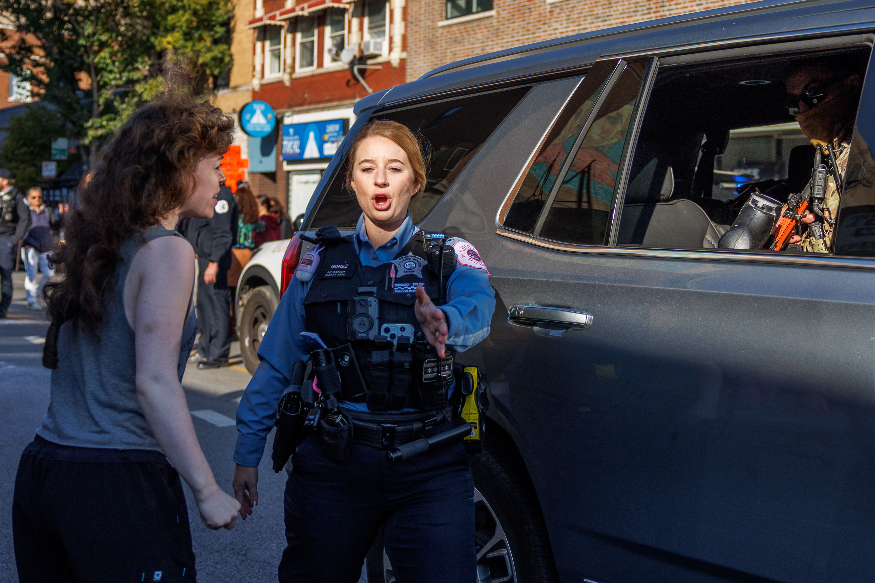 A Chicago Police officer stops people from walking in the...