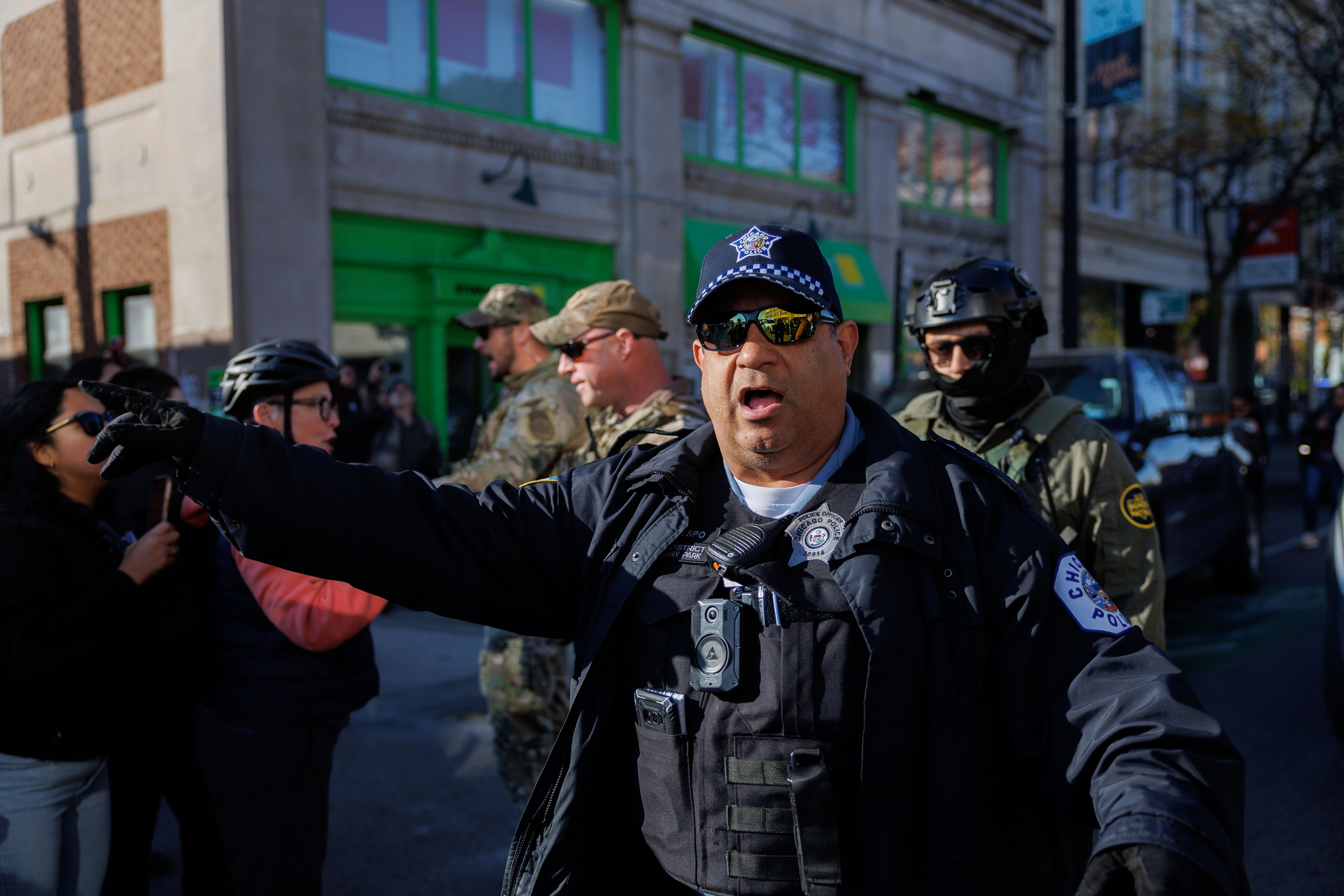 A Chicago Police officer tries to clear people from walking...