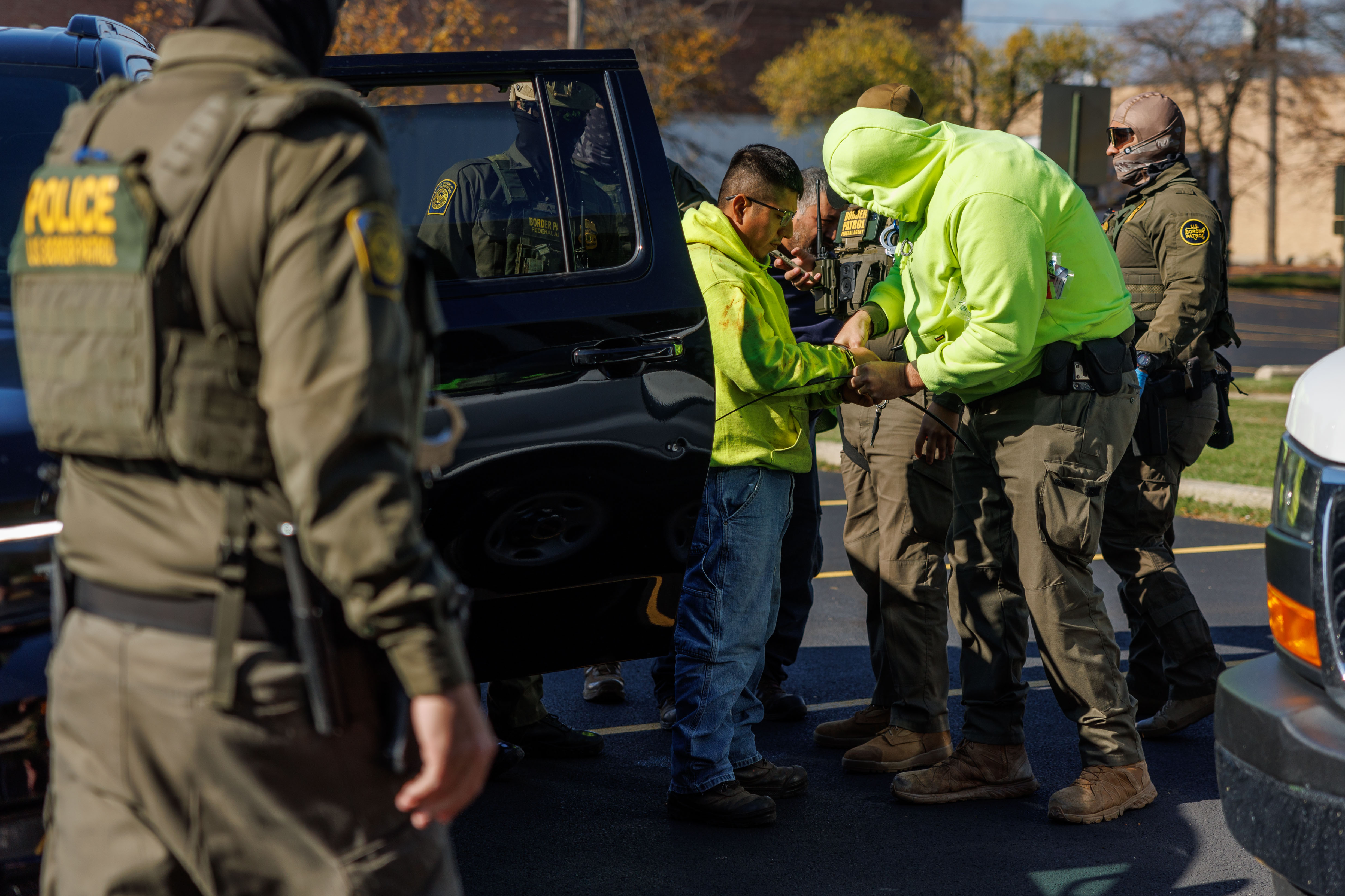 Border Patrol officers transfer a person to a van after...