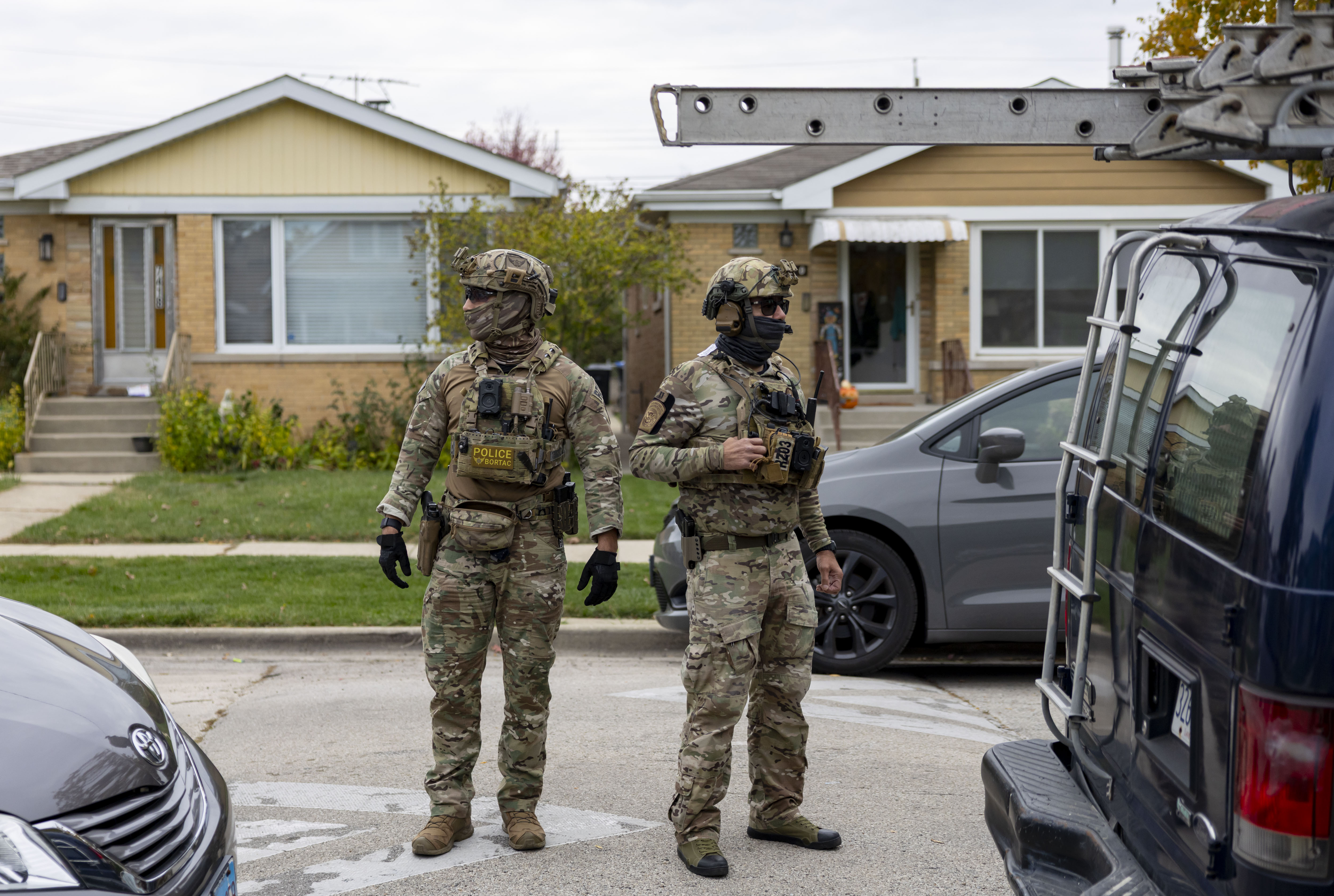 U.S. Border Patrol agents watch the street while others question...