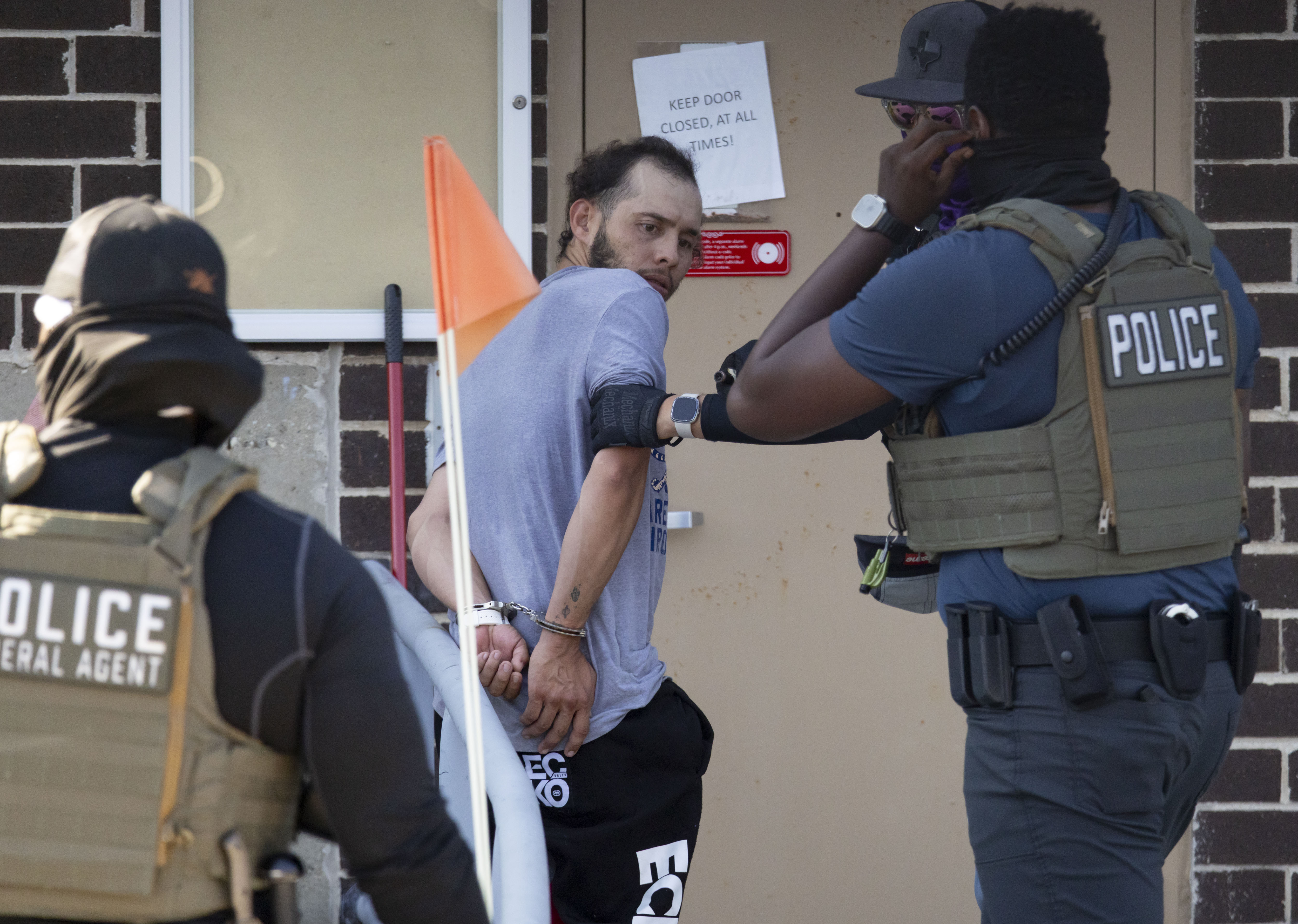 Federal agents escort a detainee into the facility on Sept....