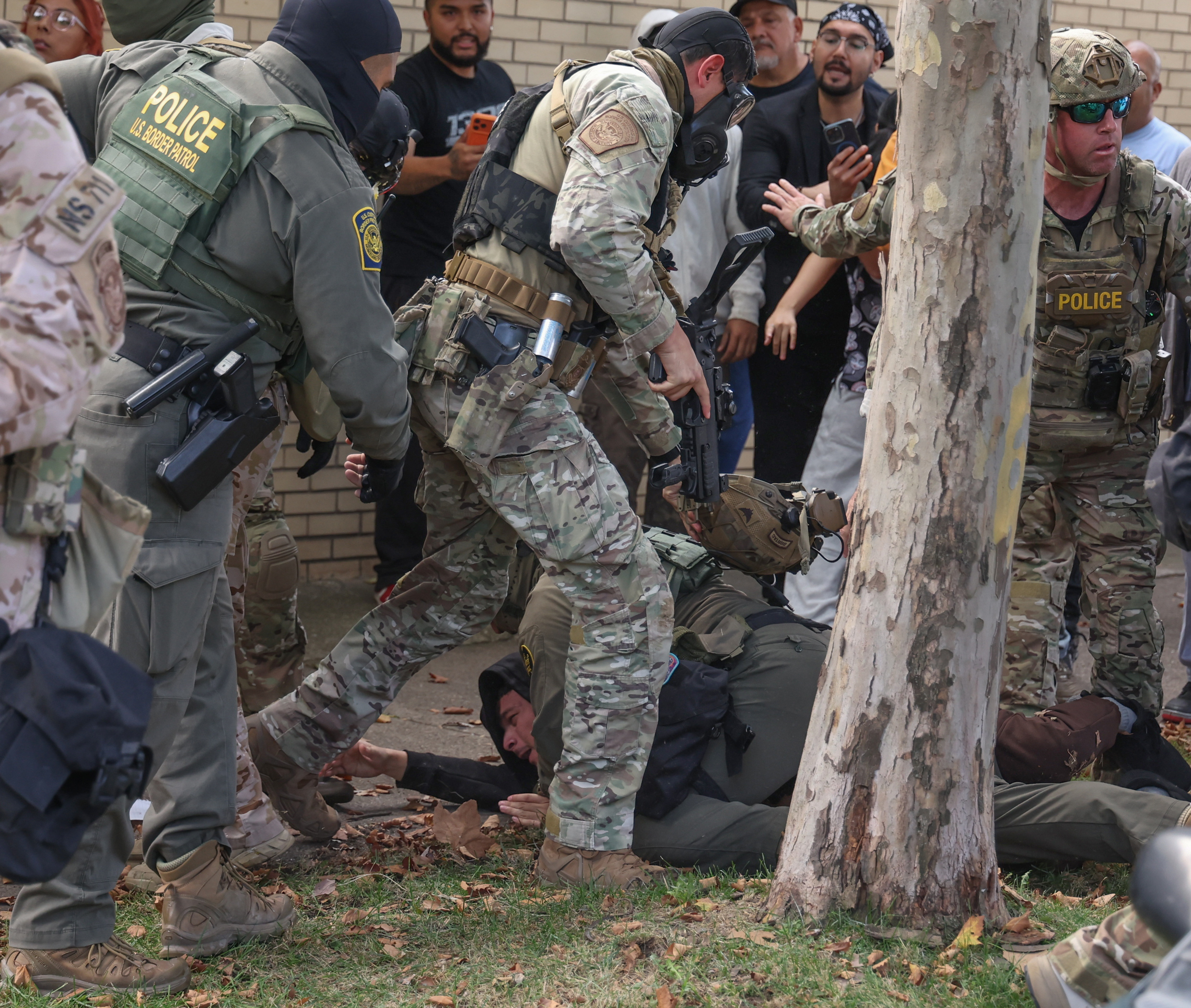 U.S. Border Patrol agents scuffle with community members in the...
