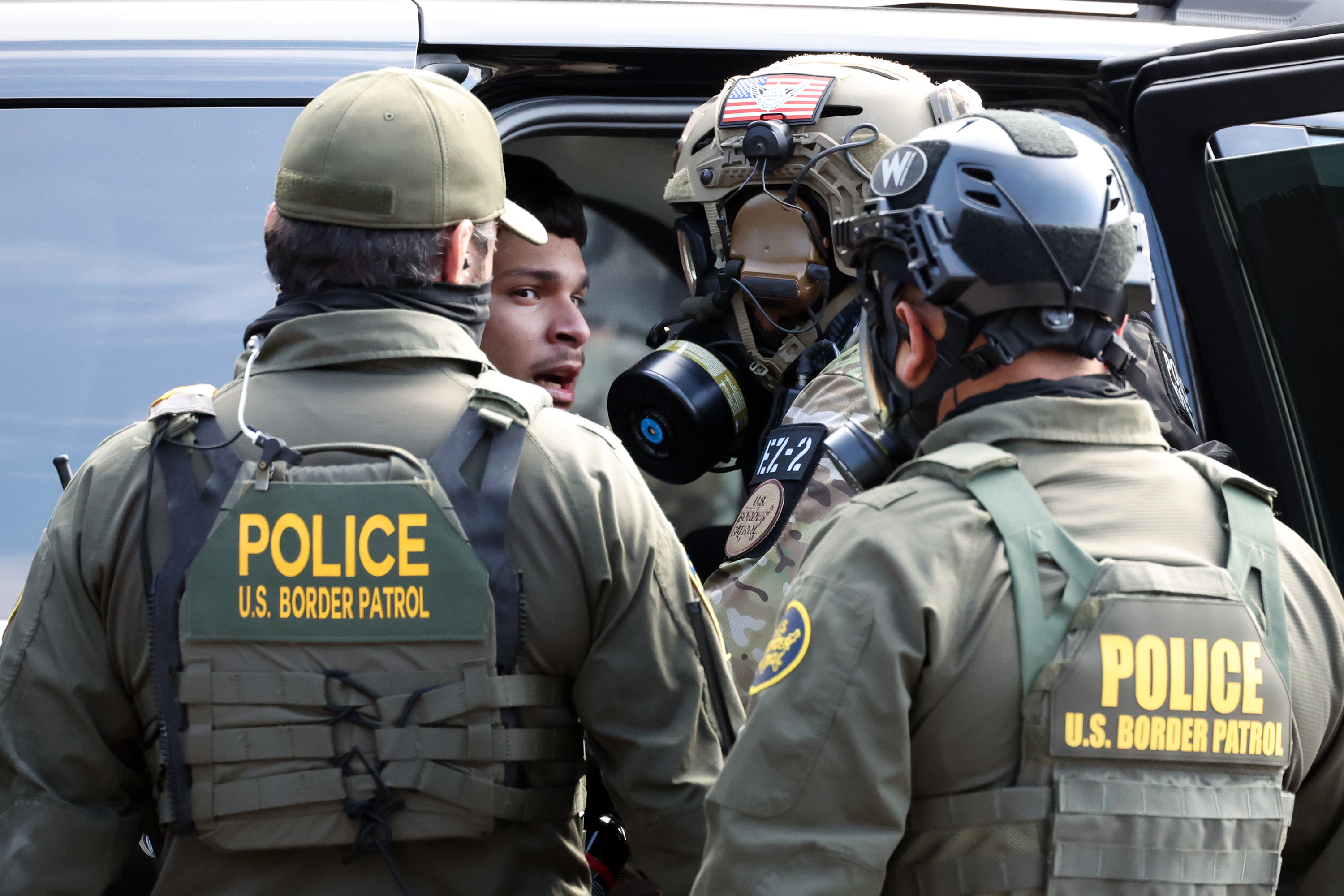 Border Patrol agents detain a person while facing off against...