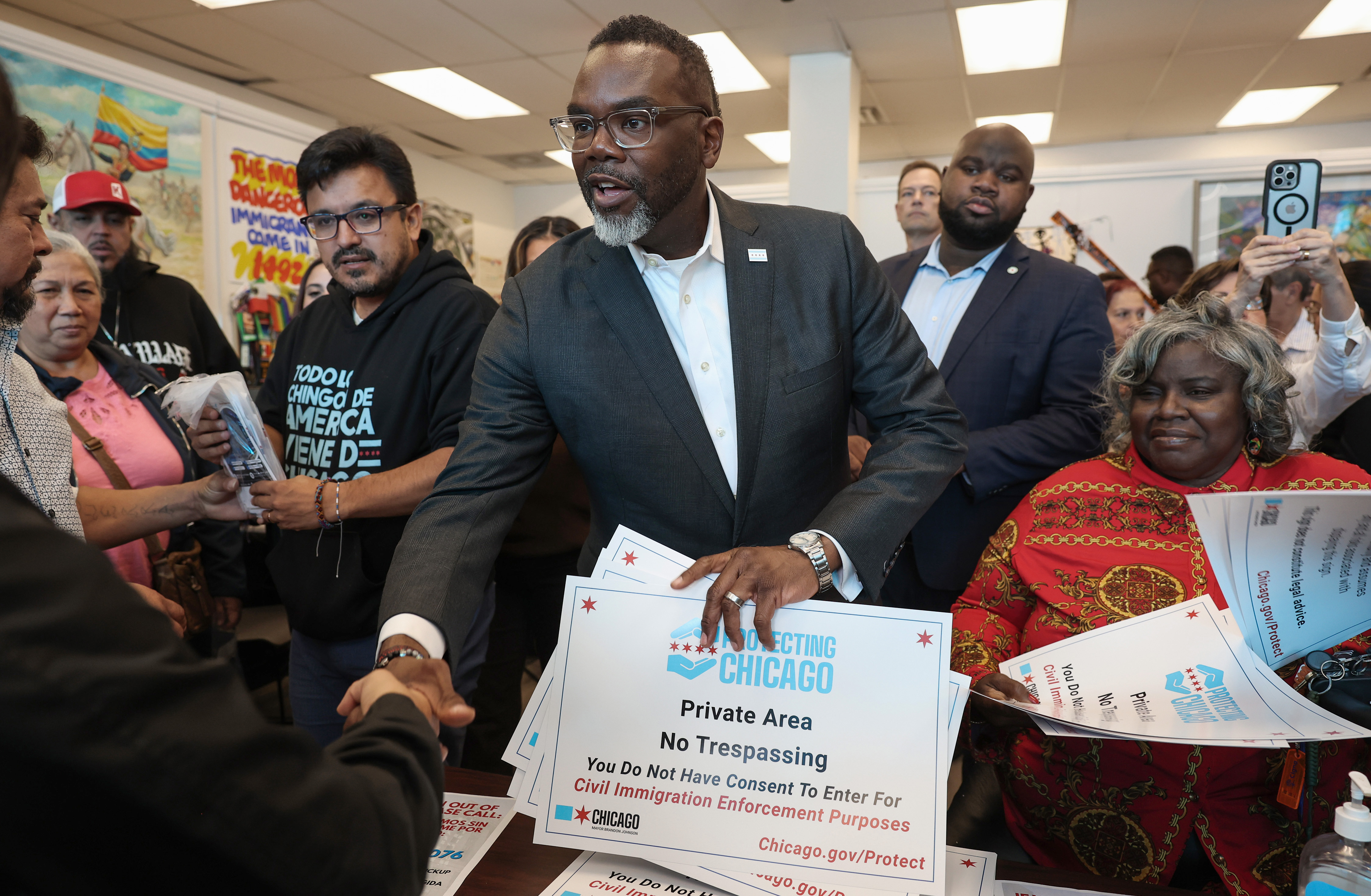 Mayor Brandon Johnson greets residents while distributing 