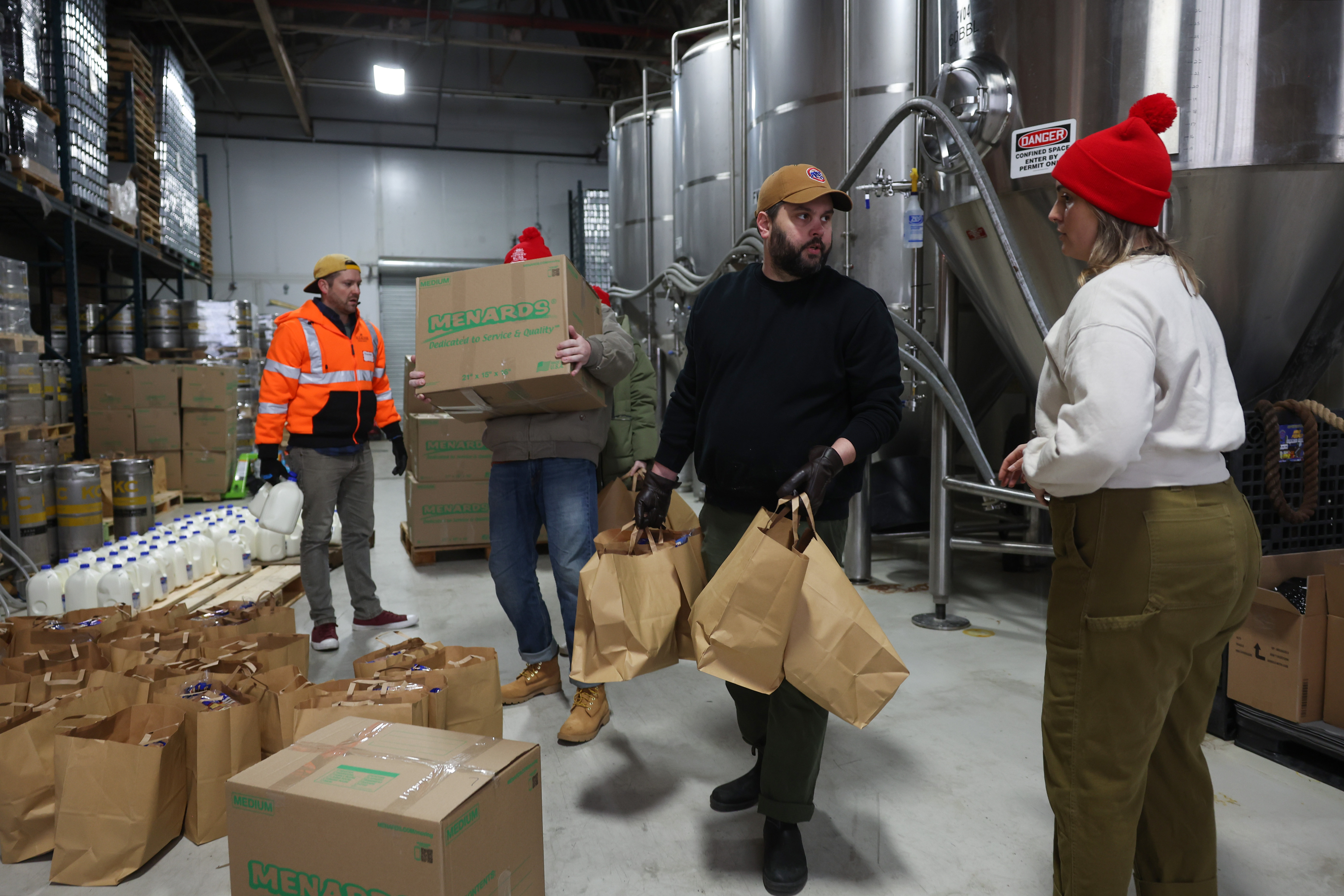 Alex Wojcik, center right, and Carley Quill, right, move groceries...