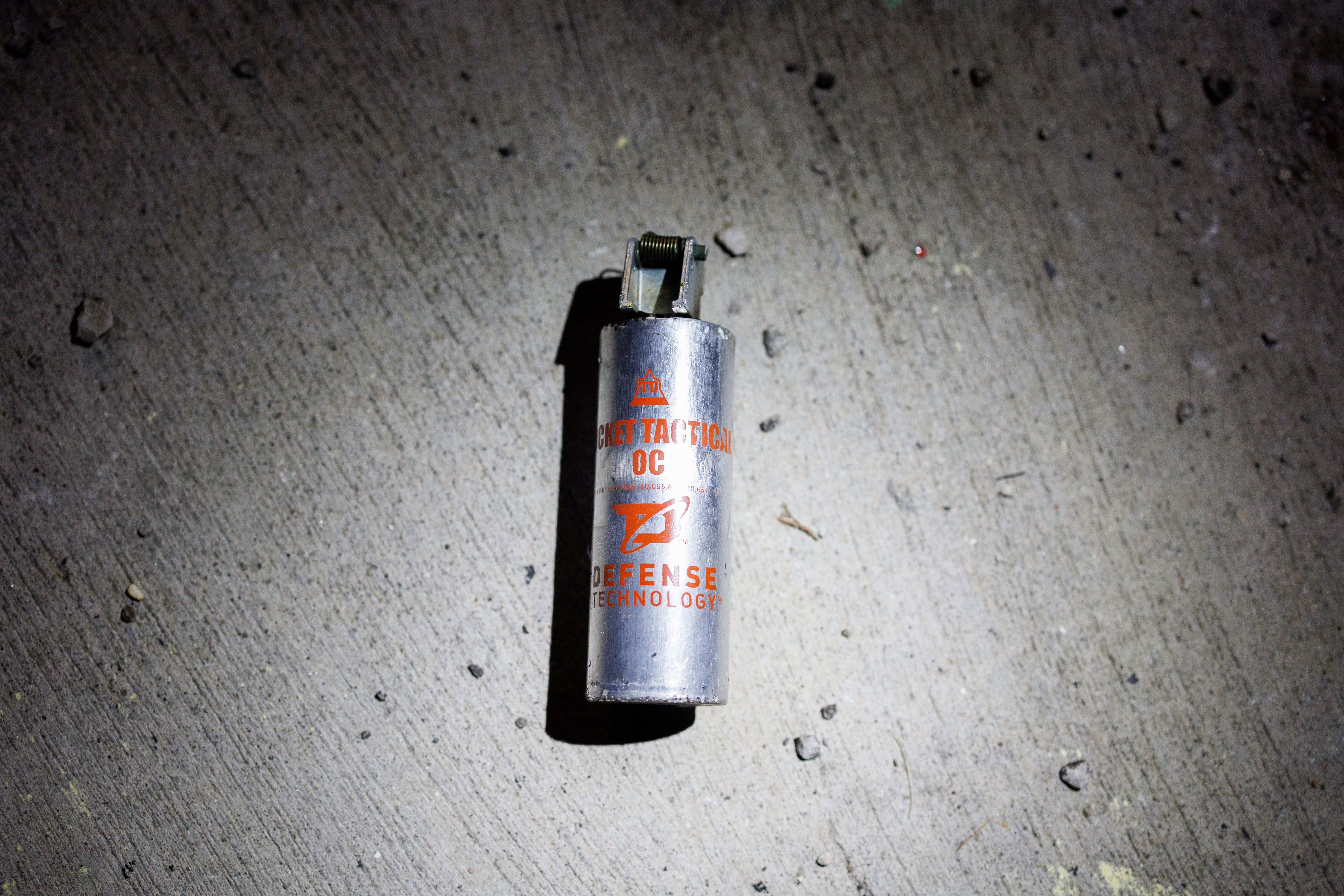 A chemical agent canister sits on the ground after being...