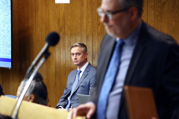 Mark Hawkins, rear, president of the Property and Recording Division at Tyler Technologies, listens as Cook County Chief Information Officer Tom Lynch addresses a meeting of the Cook County Board's technology committee at the County Building in Chicago on April 9, 2025. (Terrence Antonio James/Chicago Tribune)