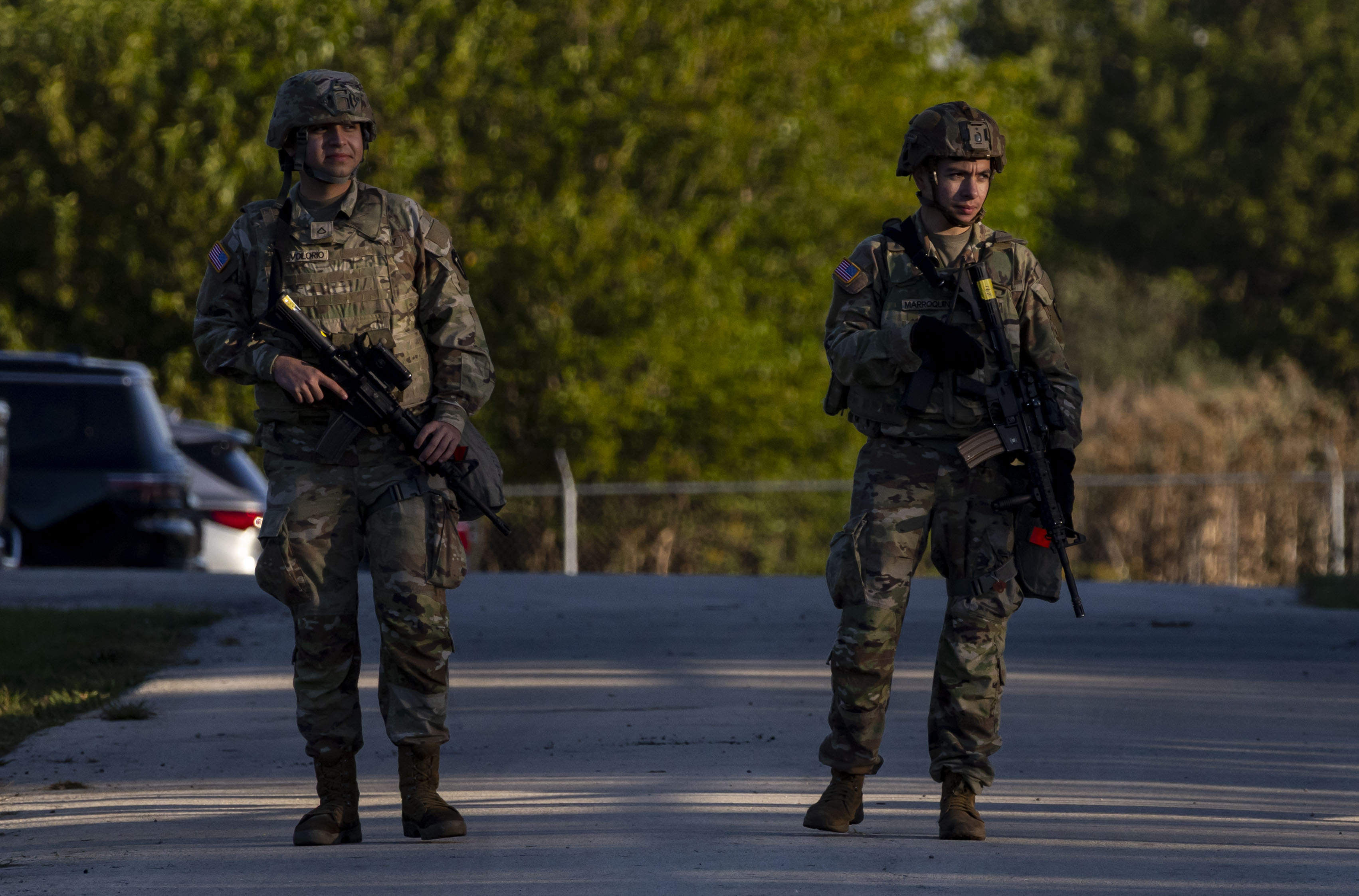 Members of the Texas National Guard stand at an entrance...