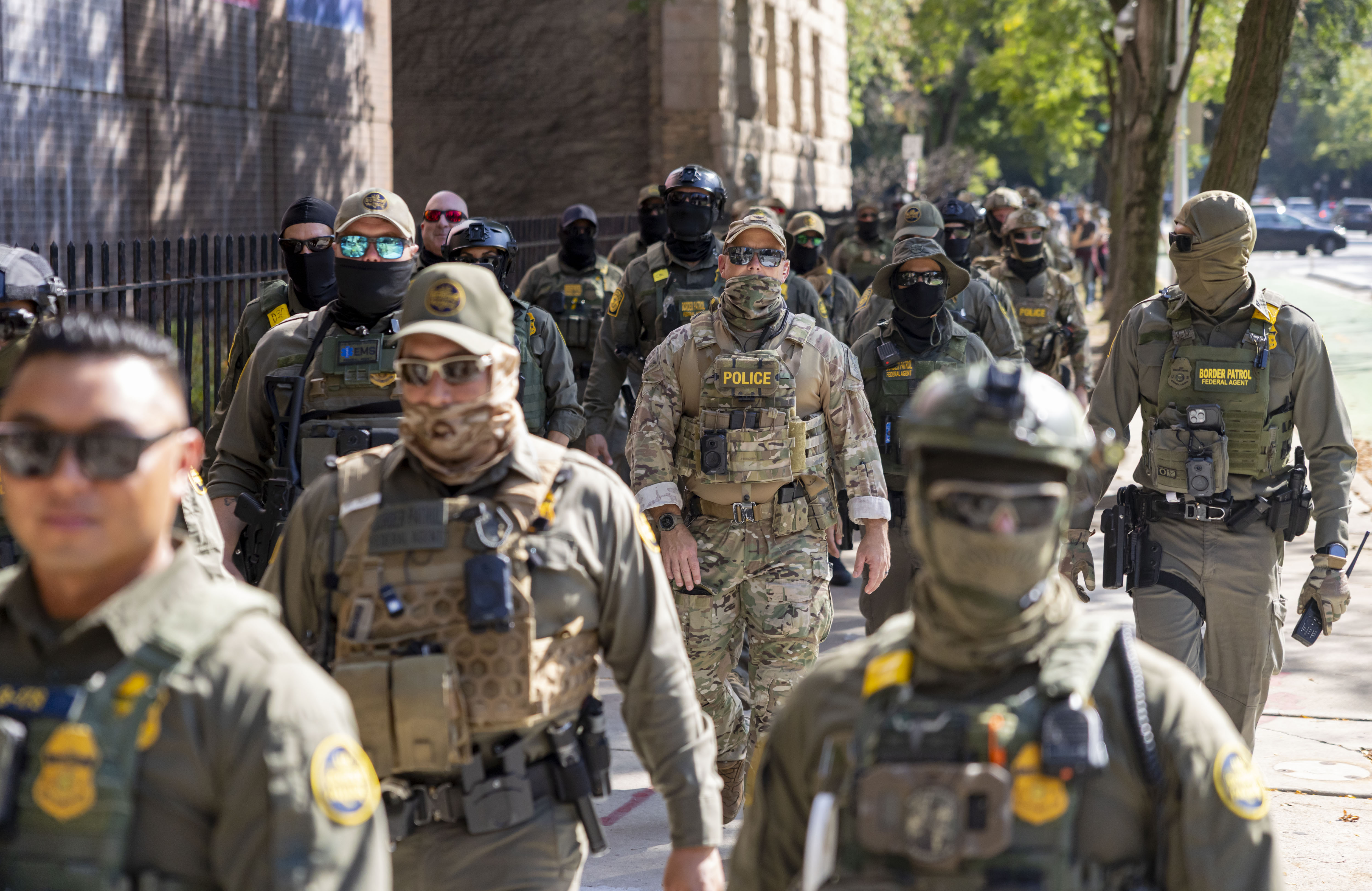 Federal agents march along North Clark Street by the Newberry...