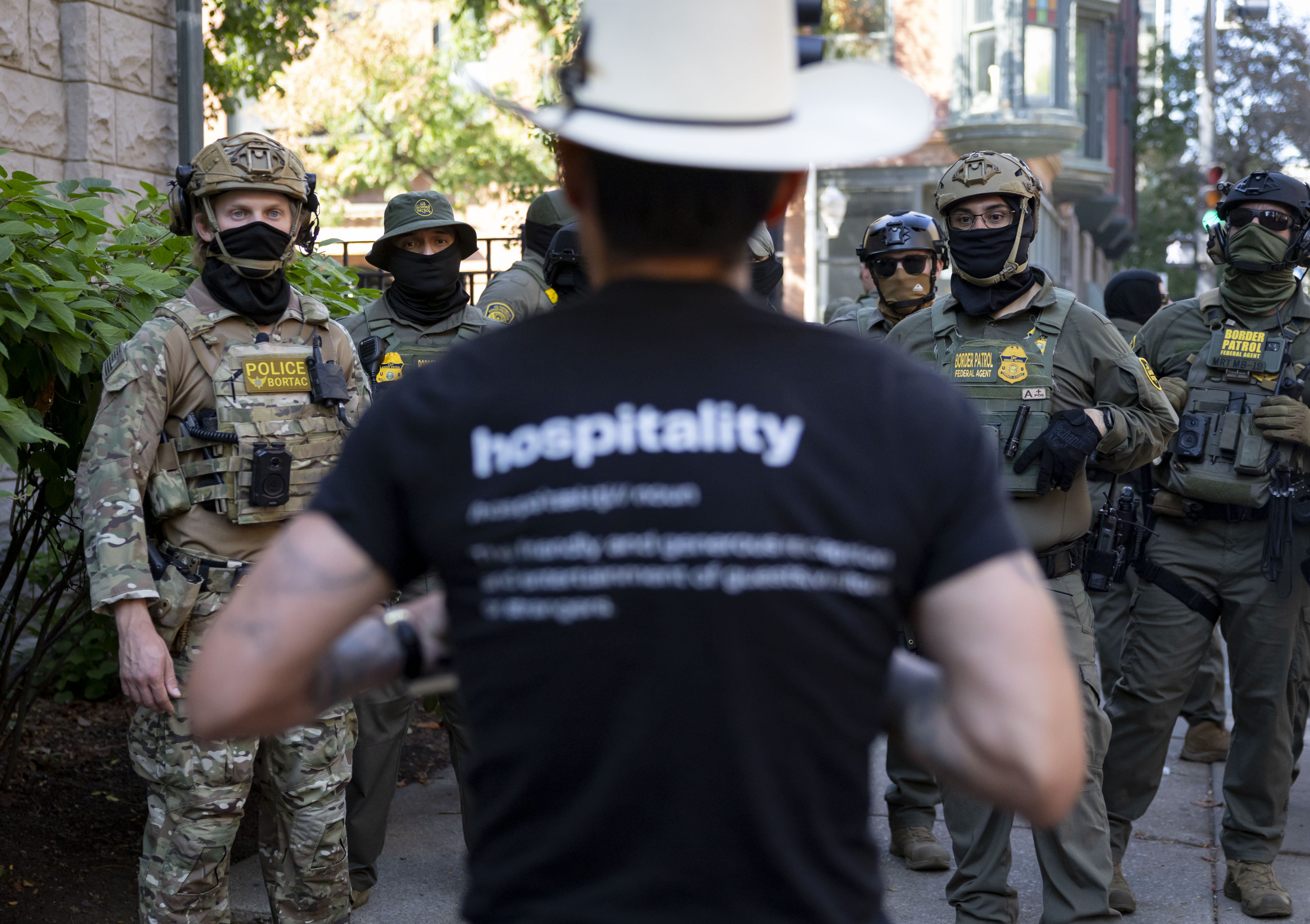 A protester talks to U.S. Border Patrol agents near the...