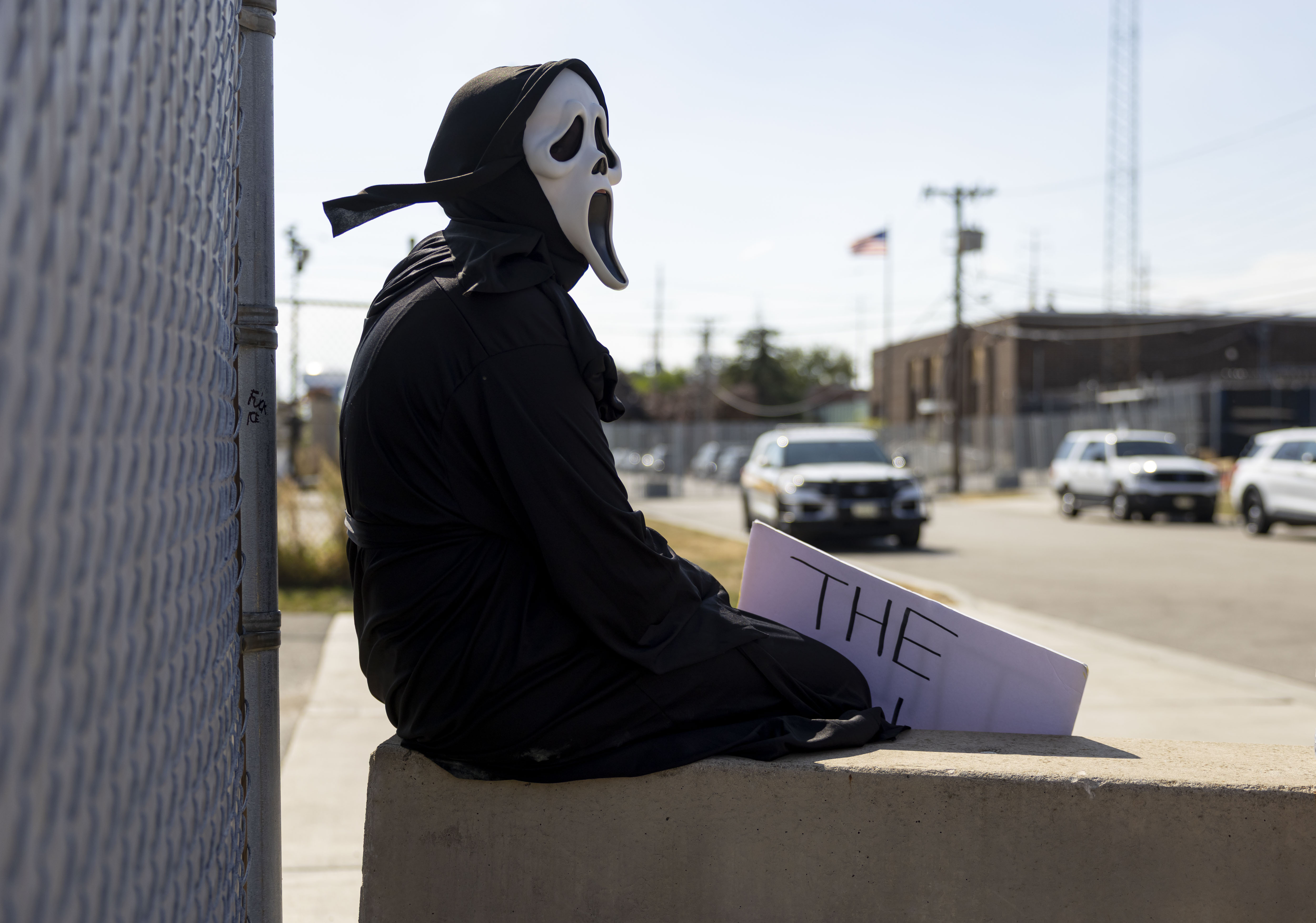 A protester sits outside, Oct. 6, 2025, at the U.S....