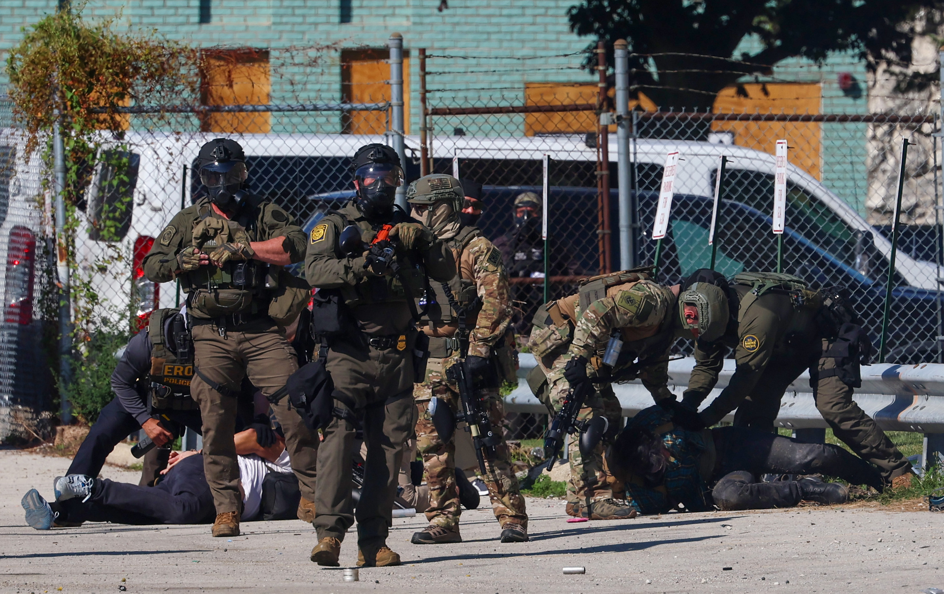 Federal agents surround and arrest two protesters along Harvard Street...