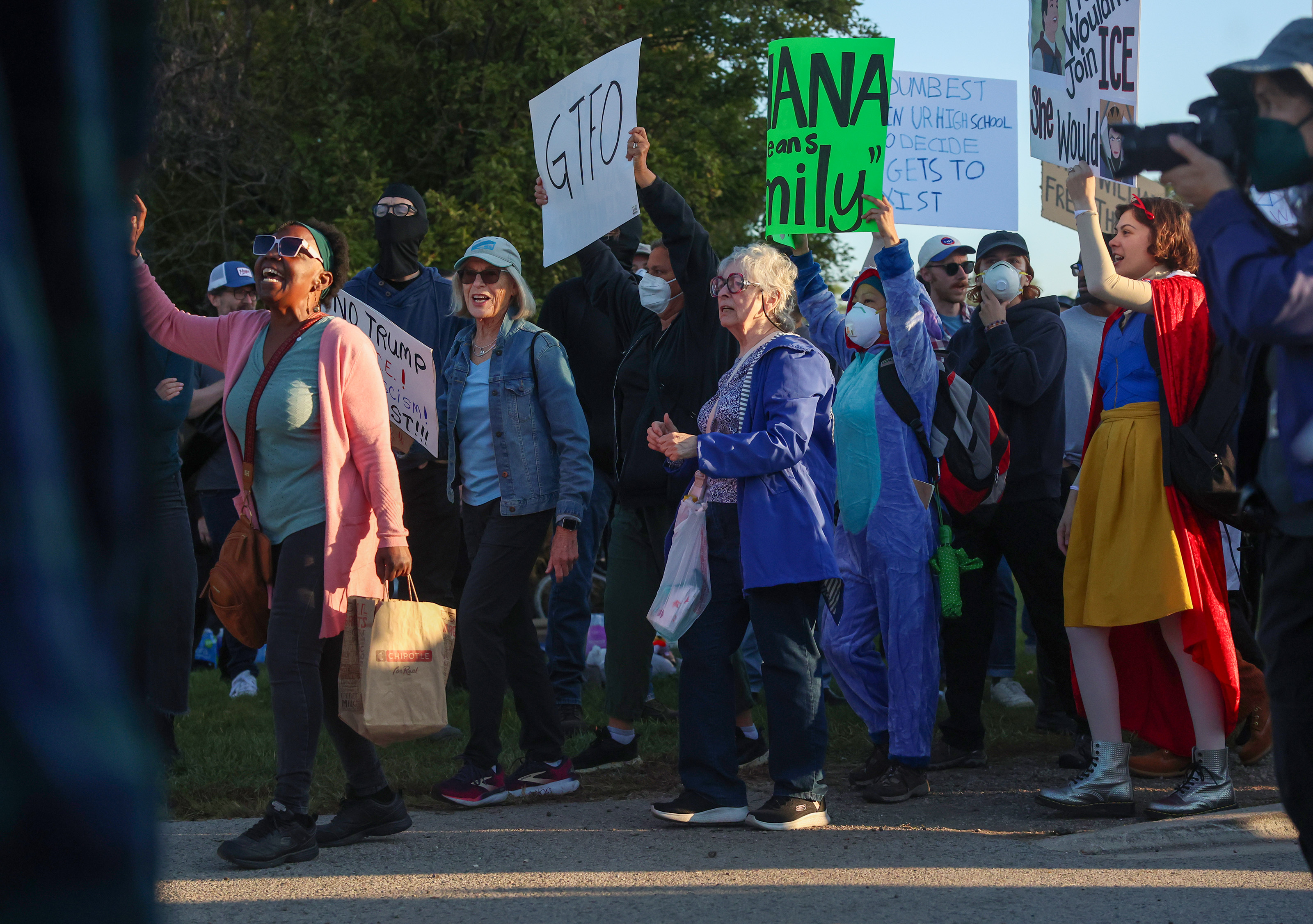 Protesters chant as they walk across Harvard Street near the...